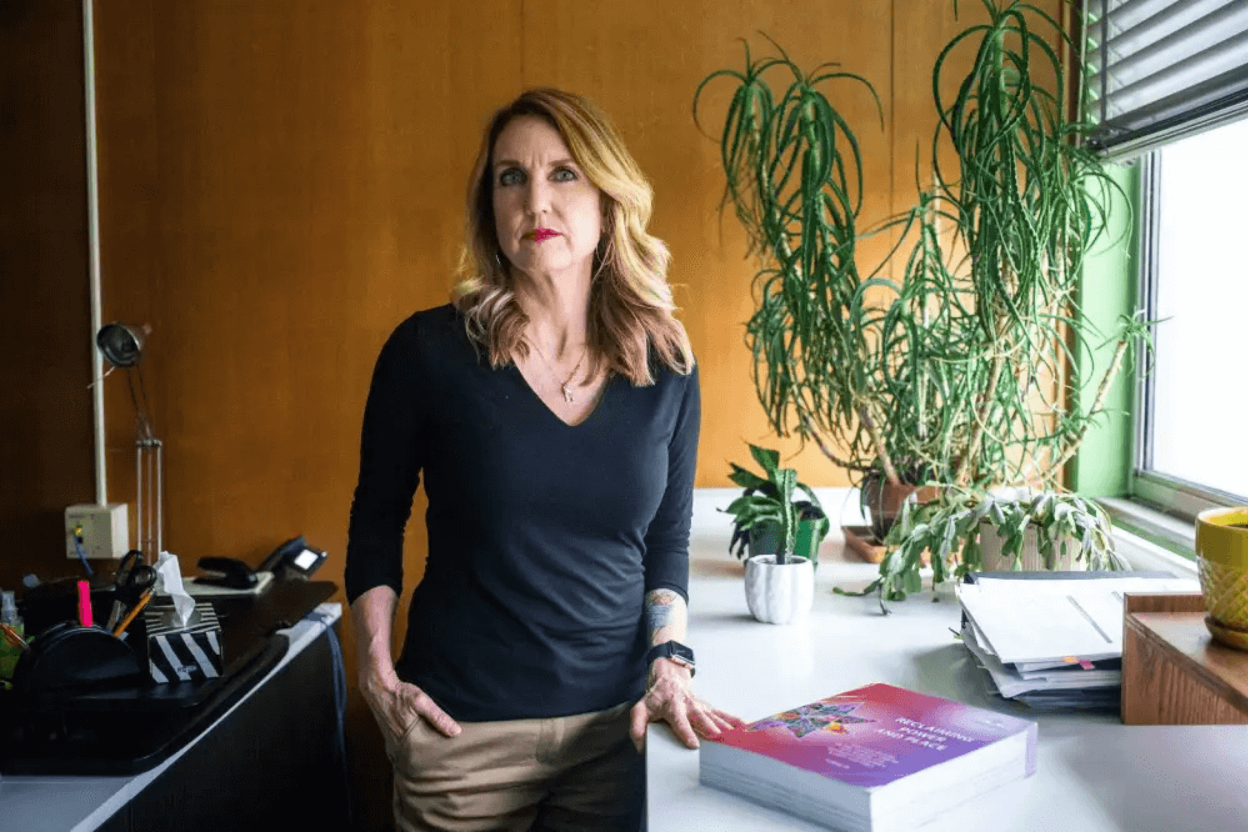 A blonde woman stands proudly at a counter (Dr. Kendra Nixon).