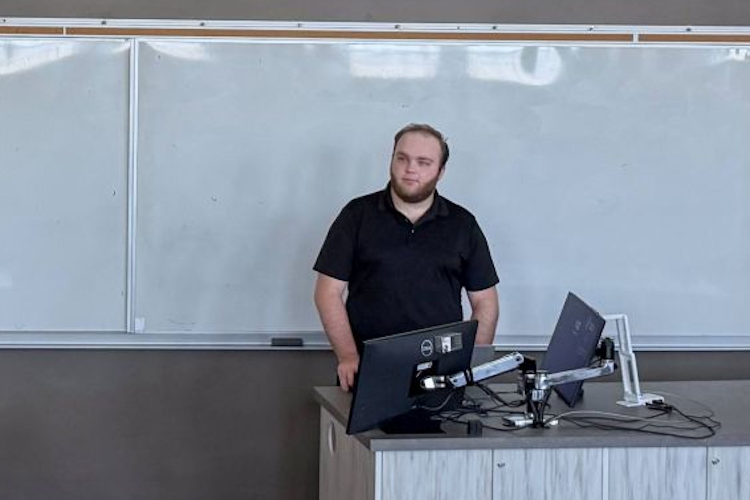 Man standing at the front of a classroom.