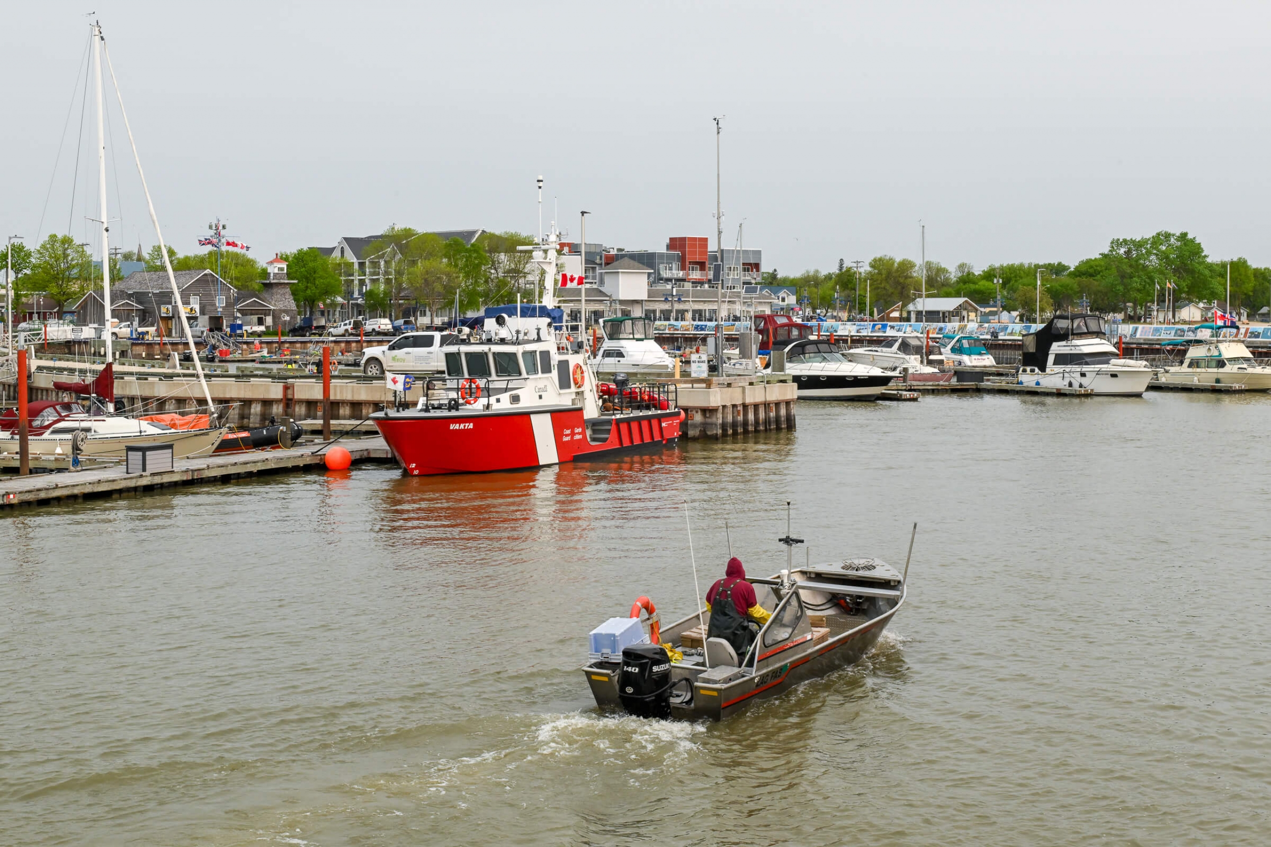 A small boat is pictured launching out of a marina