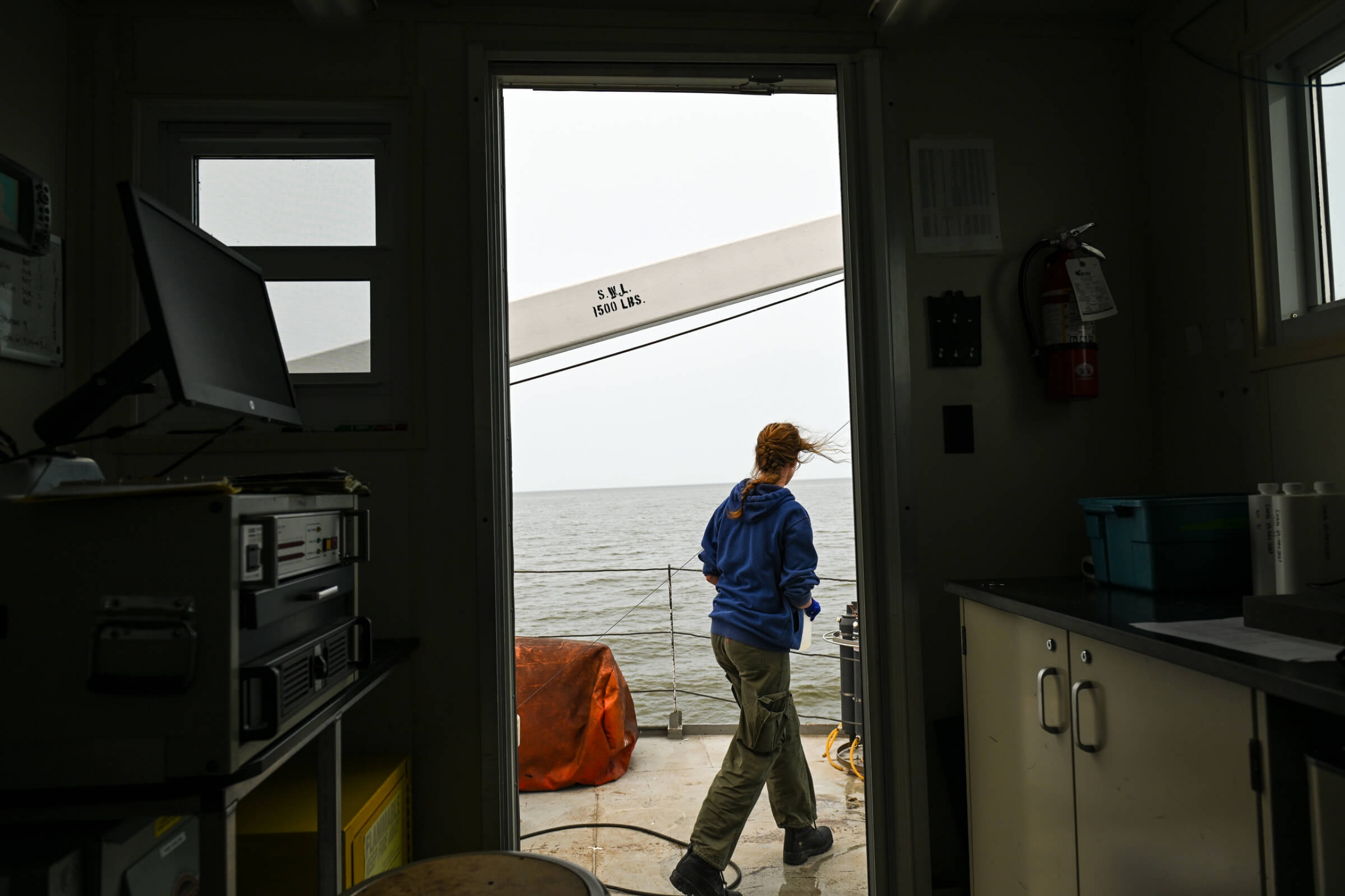 A woman walks along the deck of the boat