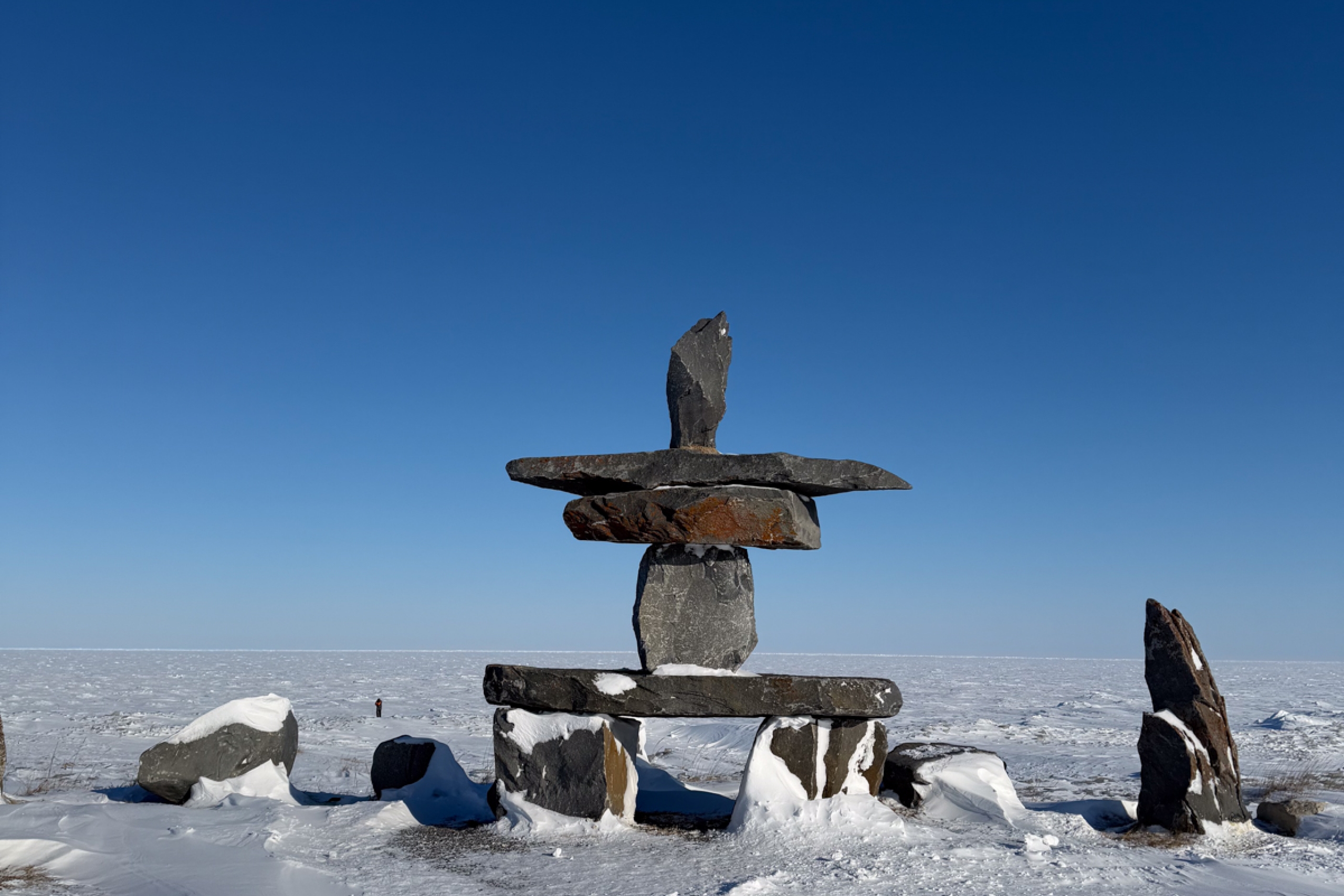 An Inukshuk in front of a frozen Hudson's Bay.
