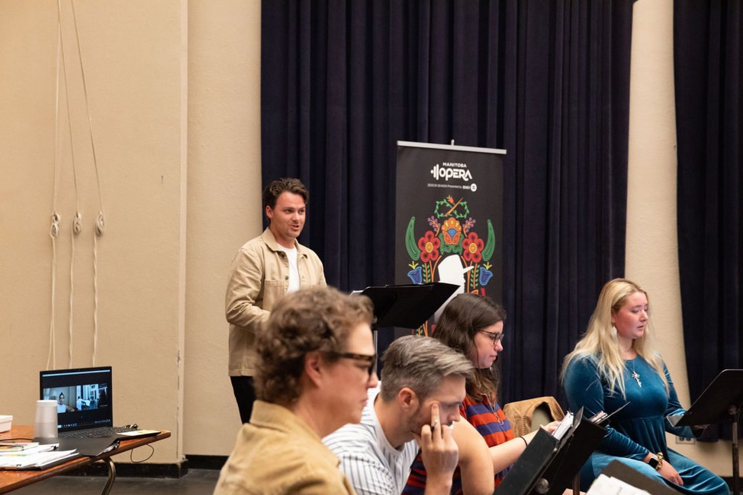 Person stands in front of circle of people at a workshop.