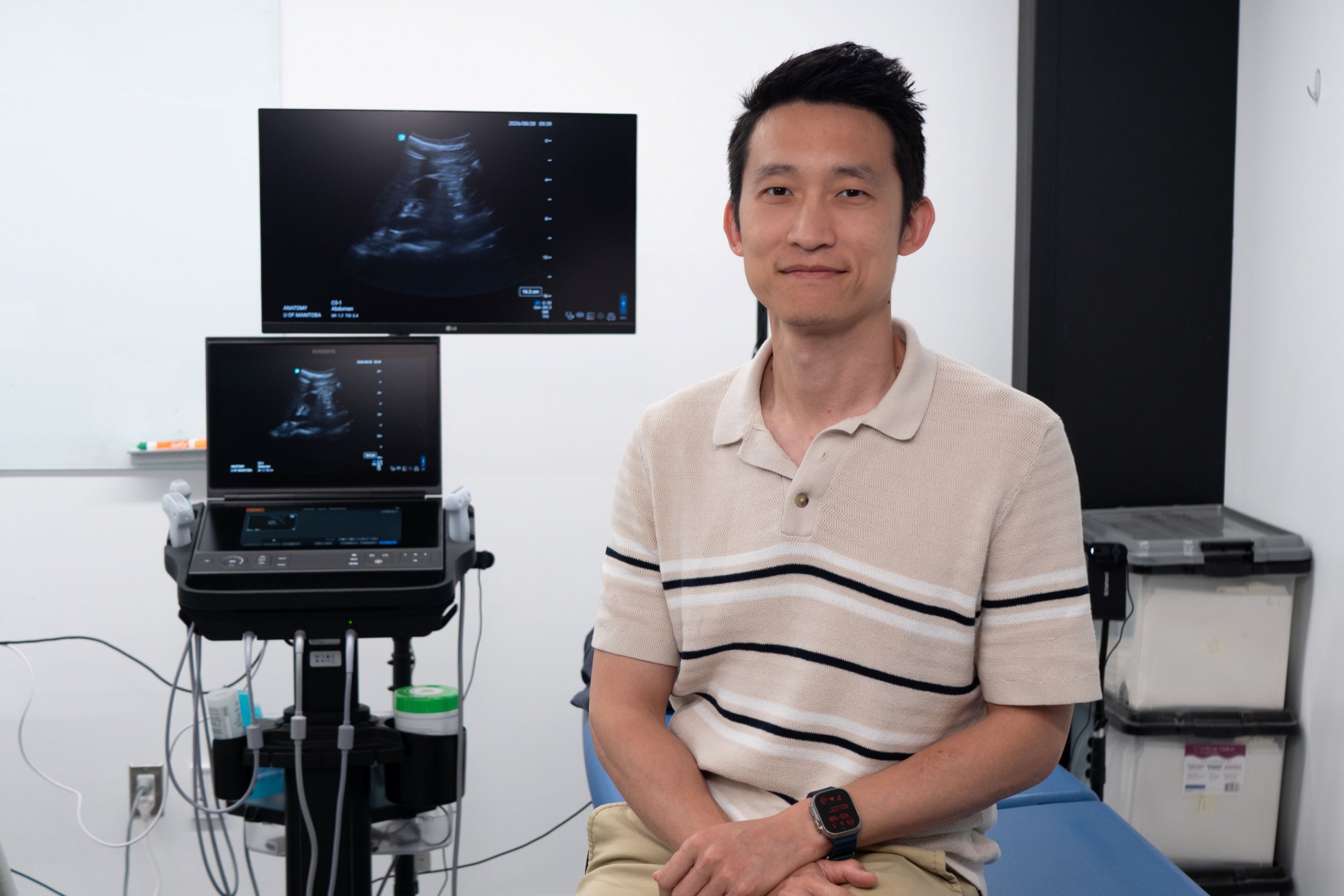 Terry Li sits beside ultrasound machine