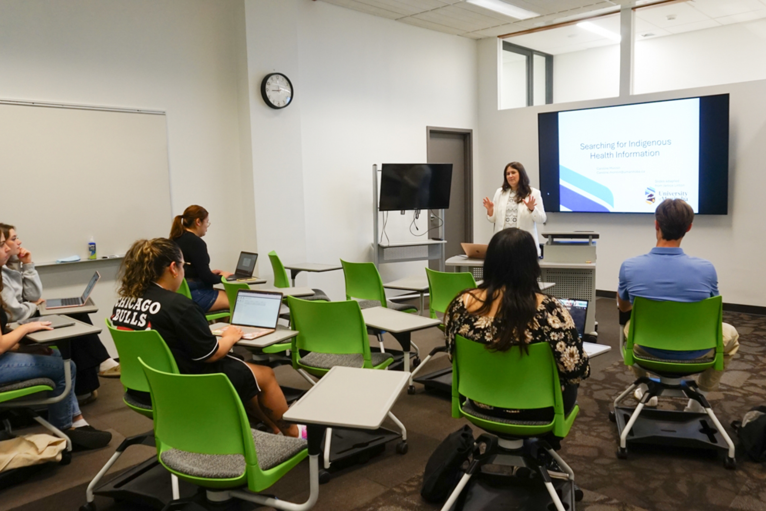 Students listen to an instructor in a classroom.