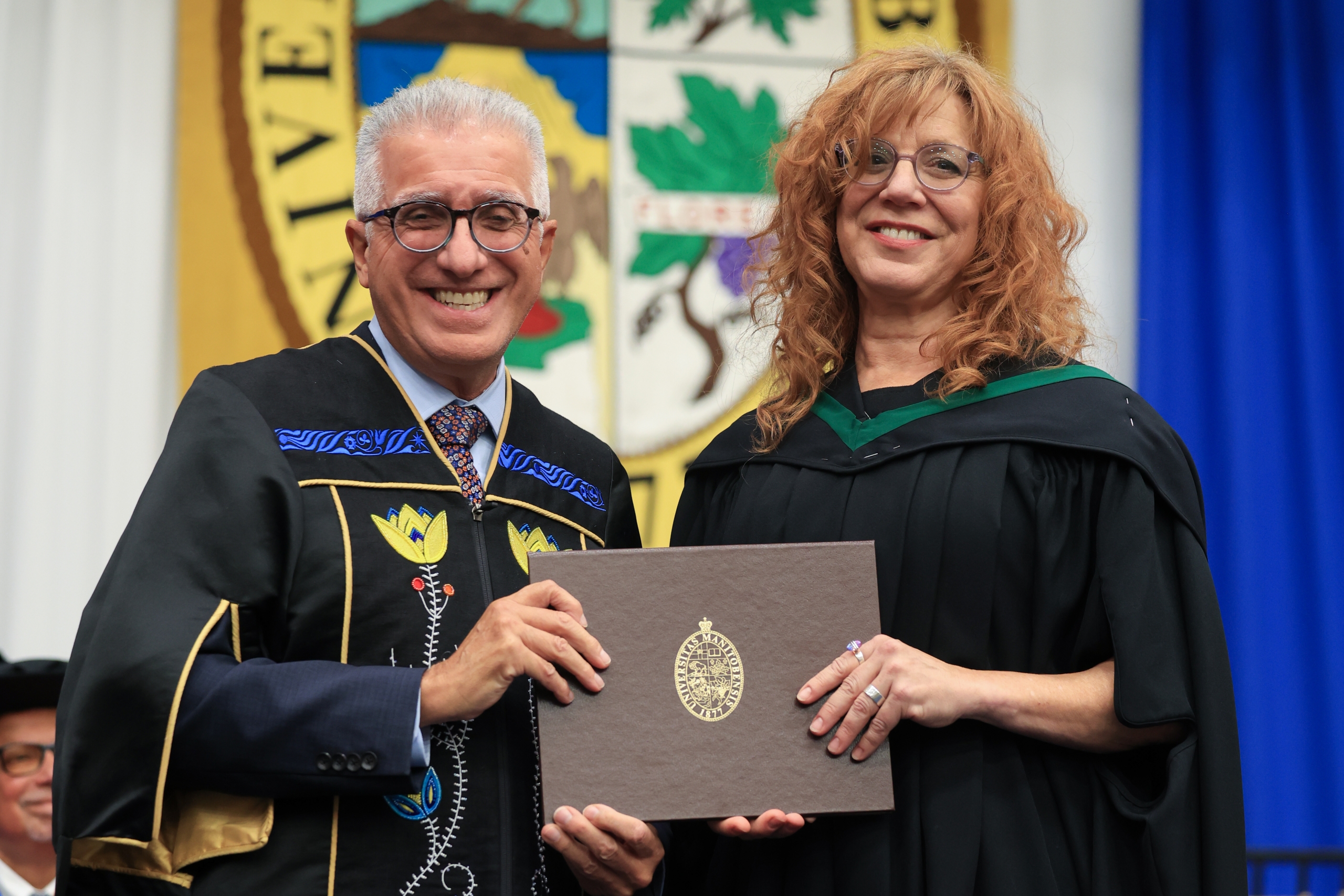 UM President Michael Bennaroch presents an award to Lisa Diamond-Burchuk.