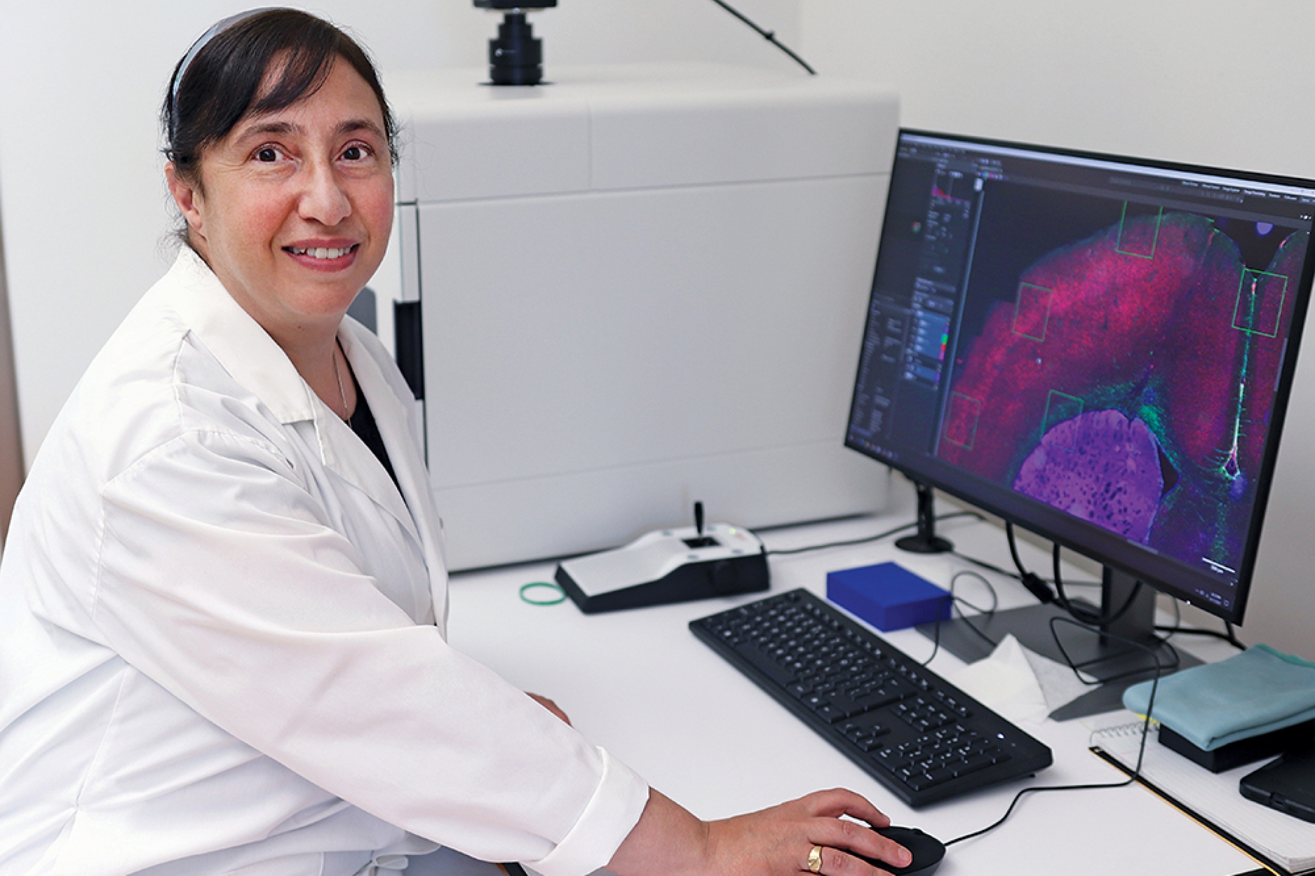 Lucy Marzban smiles at the camera in front of a computer.