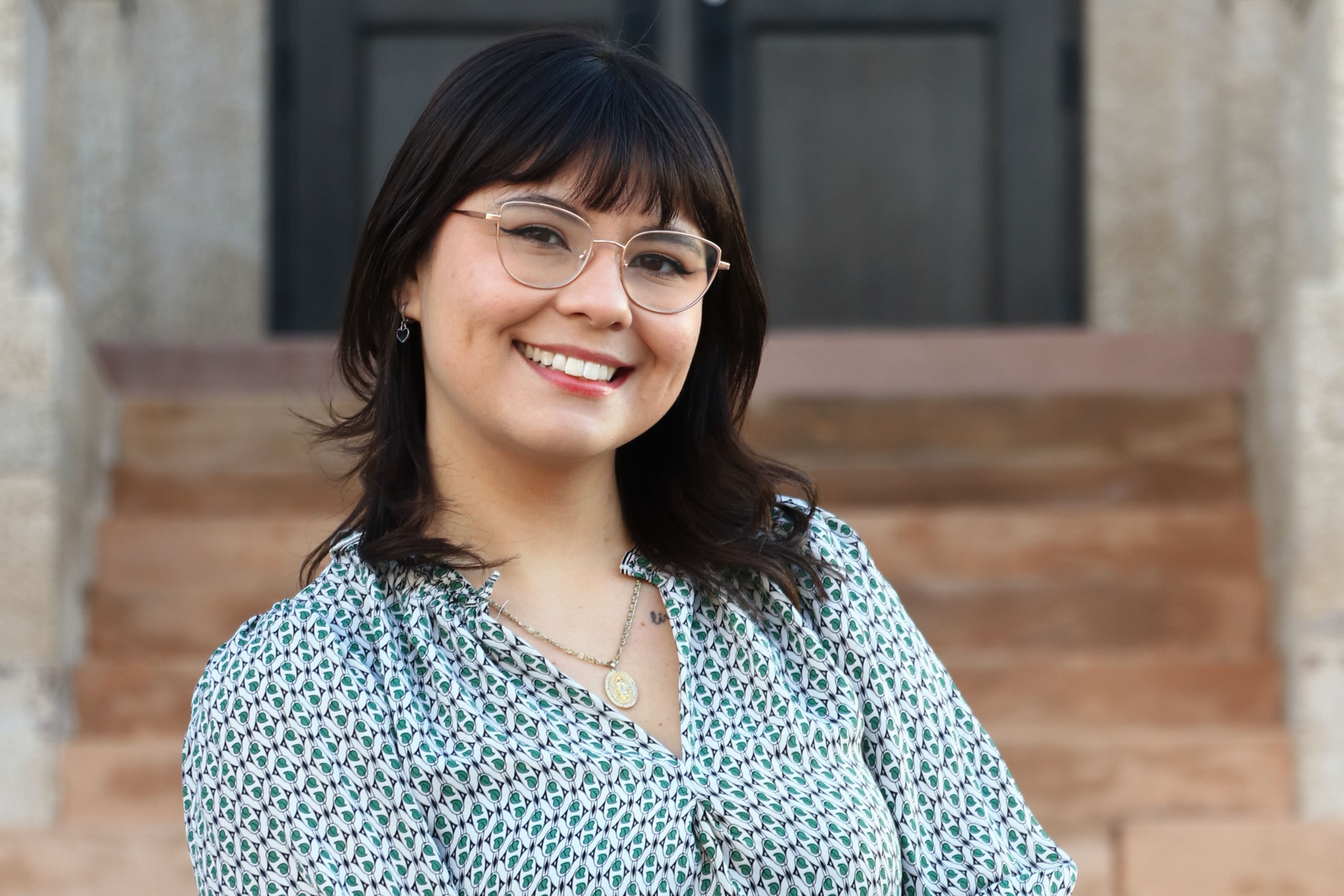 Luma Clarindo Lopes smiling while seated on outdoor steps.