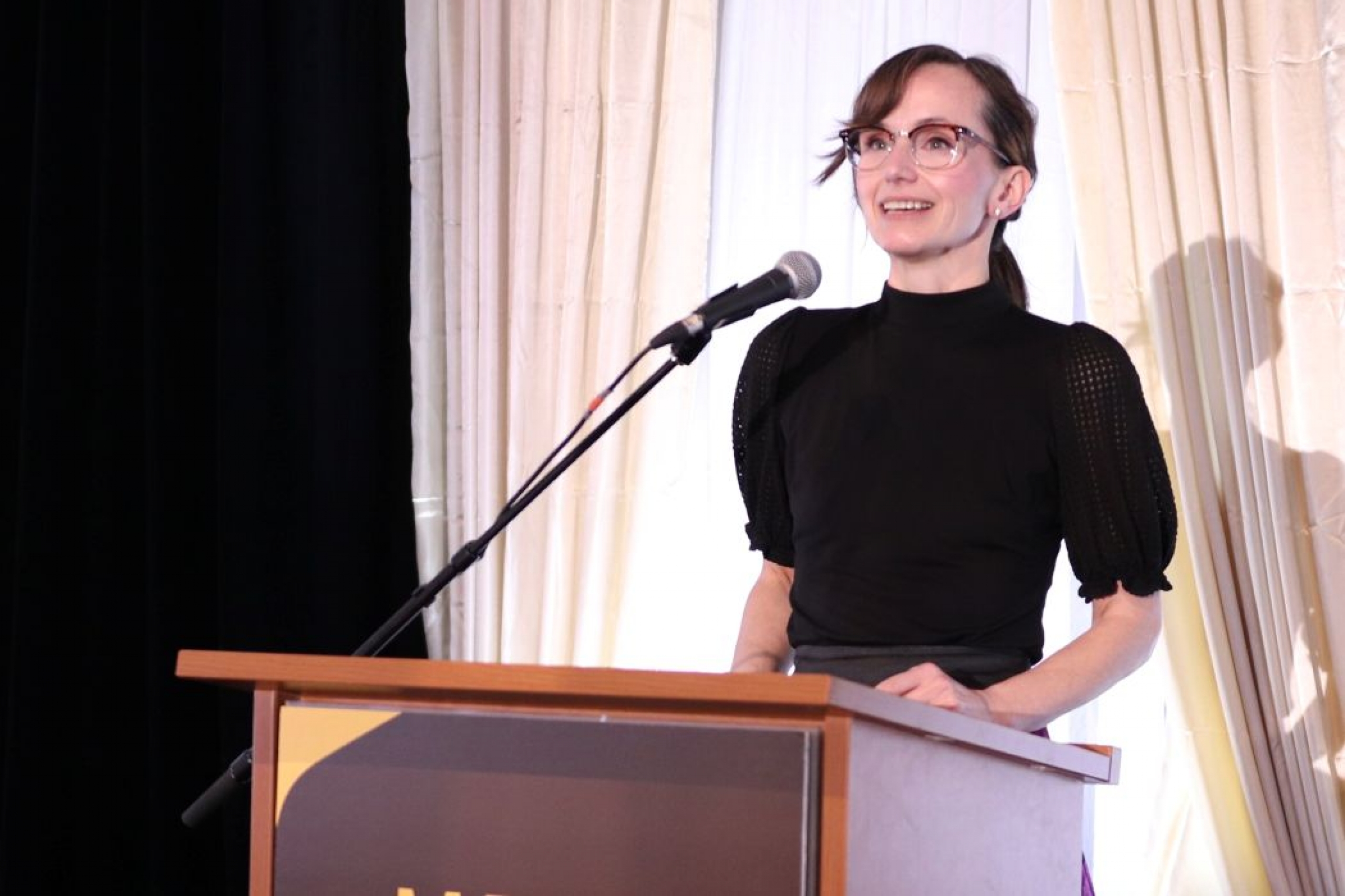 Minister Renee Cable speaks at a lectern. 