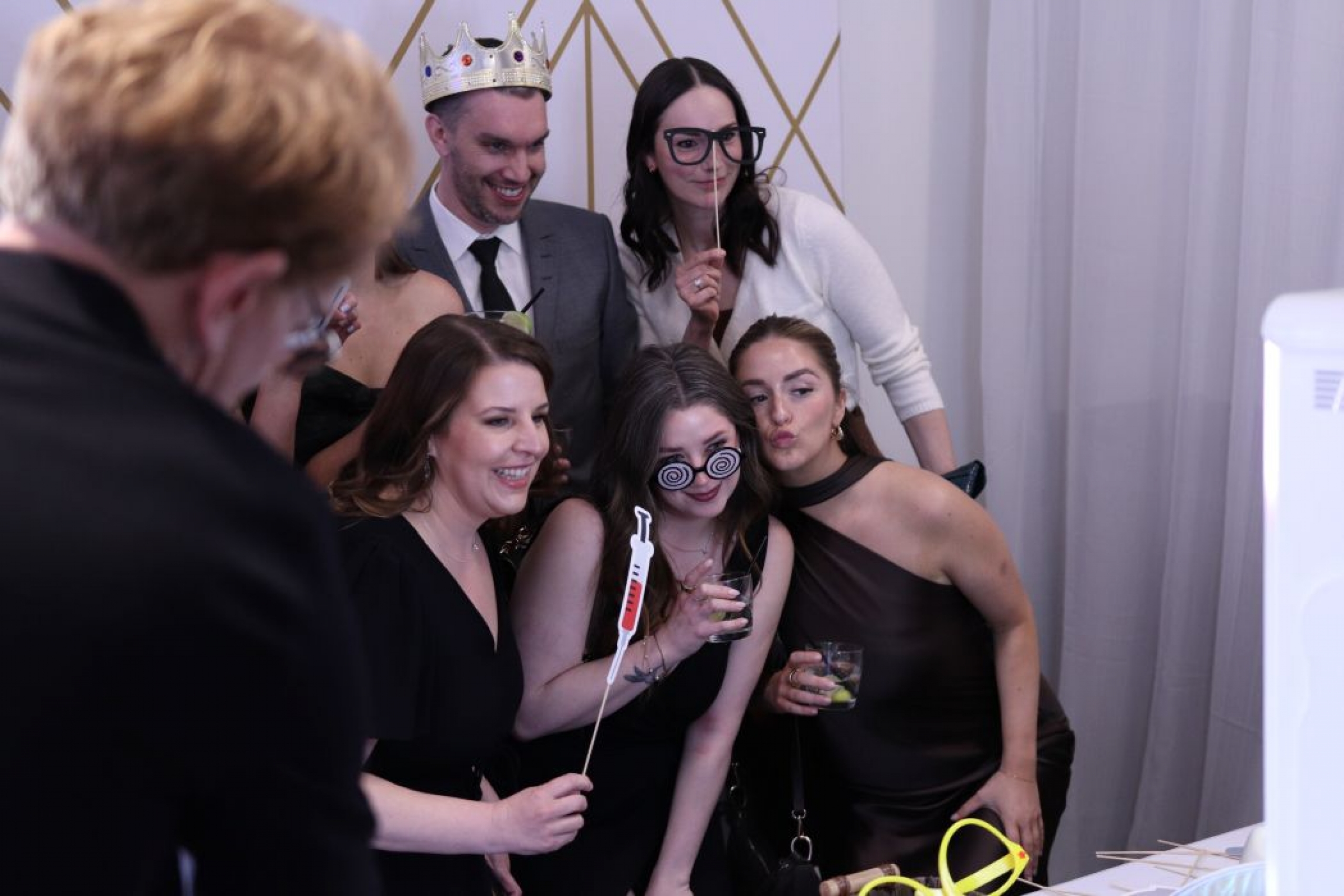 A group of people pose in a photobooth. 