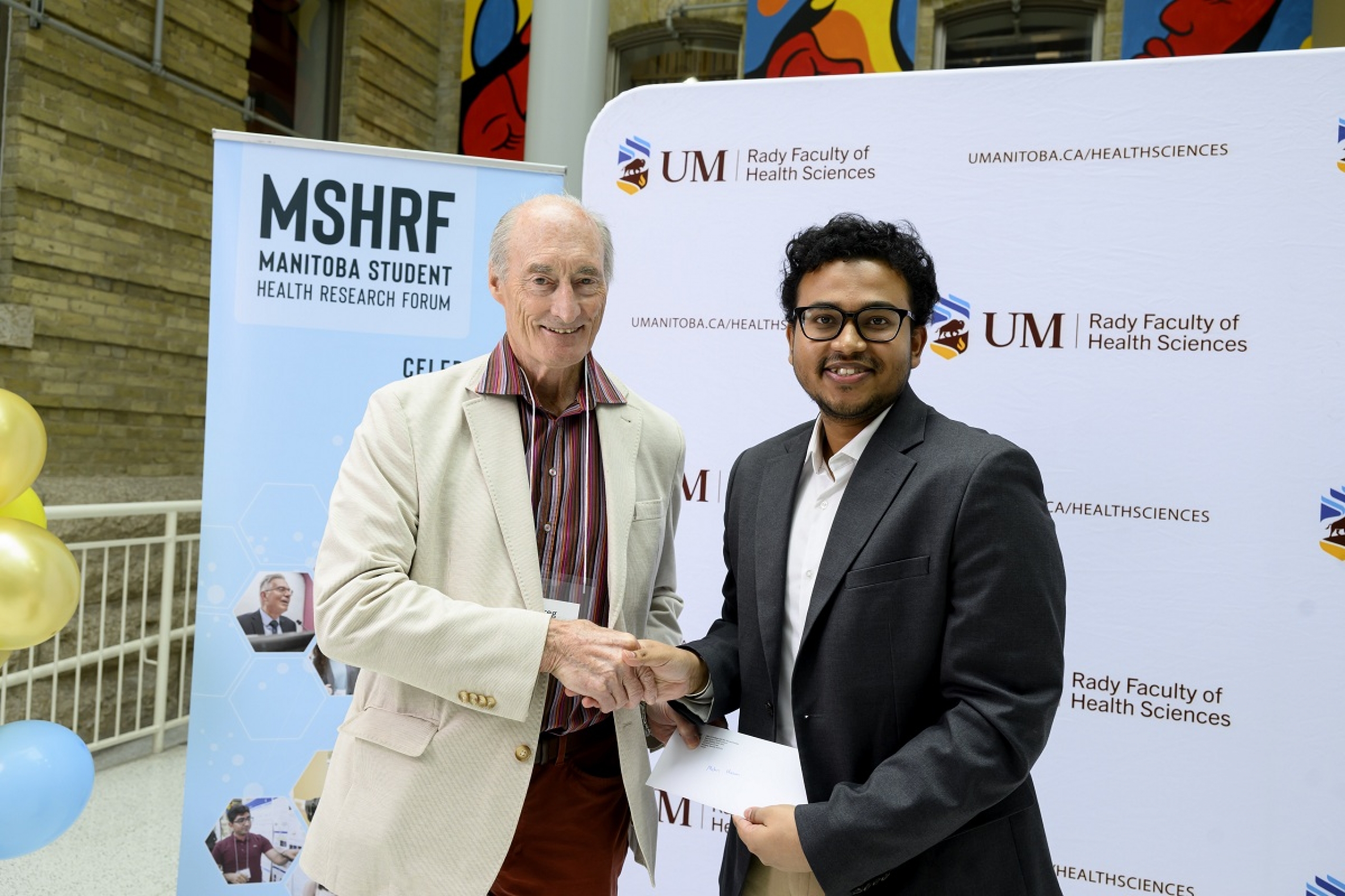 Dr. Greg Hammond, Executive Director of the Manitoba Medical Service Foundation (MMSF), presenting an award to Mahin Hasan.