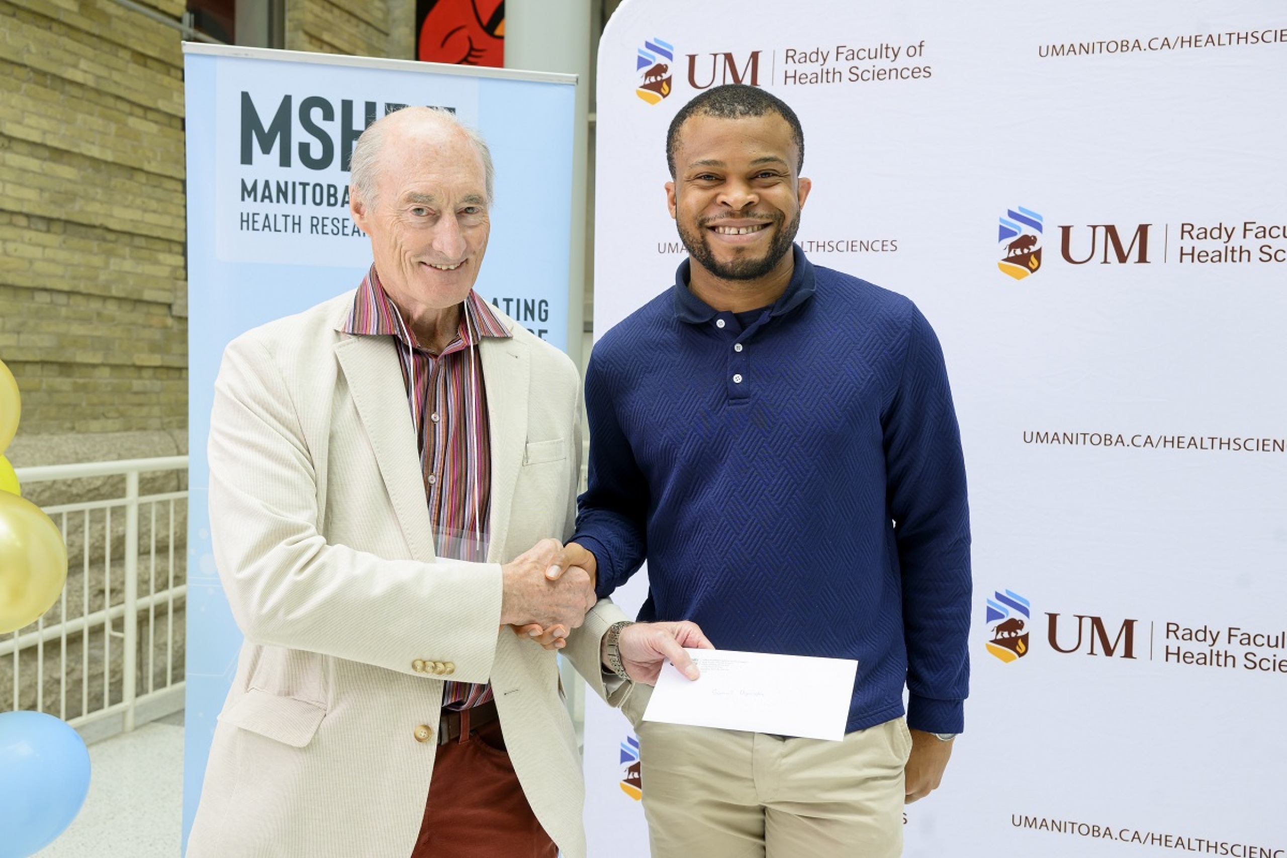 Dr. Greg Hammond presenting an award to Samuel Ogunsola.
