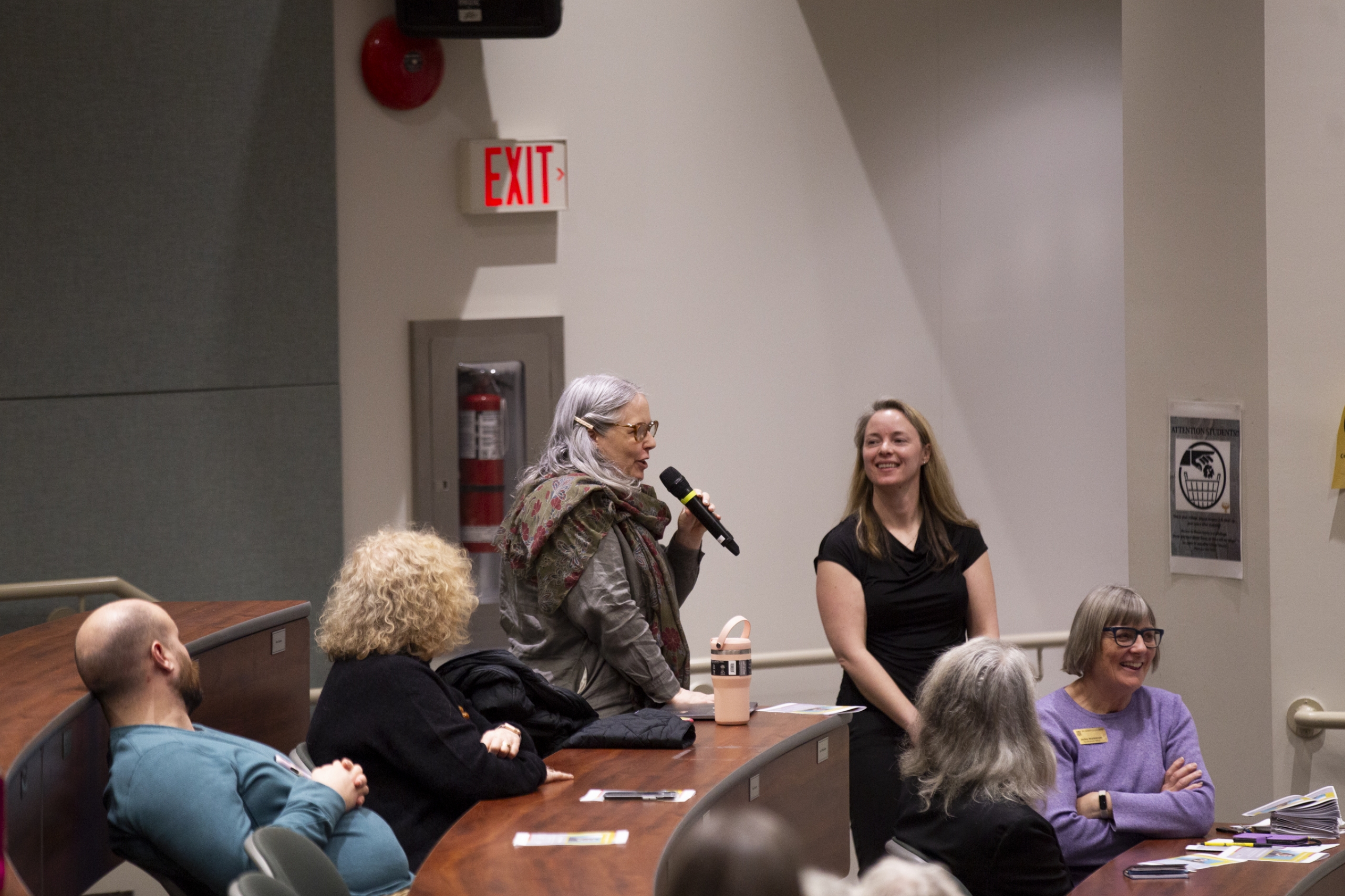 Dr. Adele Perry standing to ask a question with a microphone