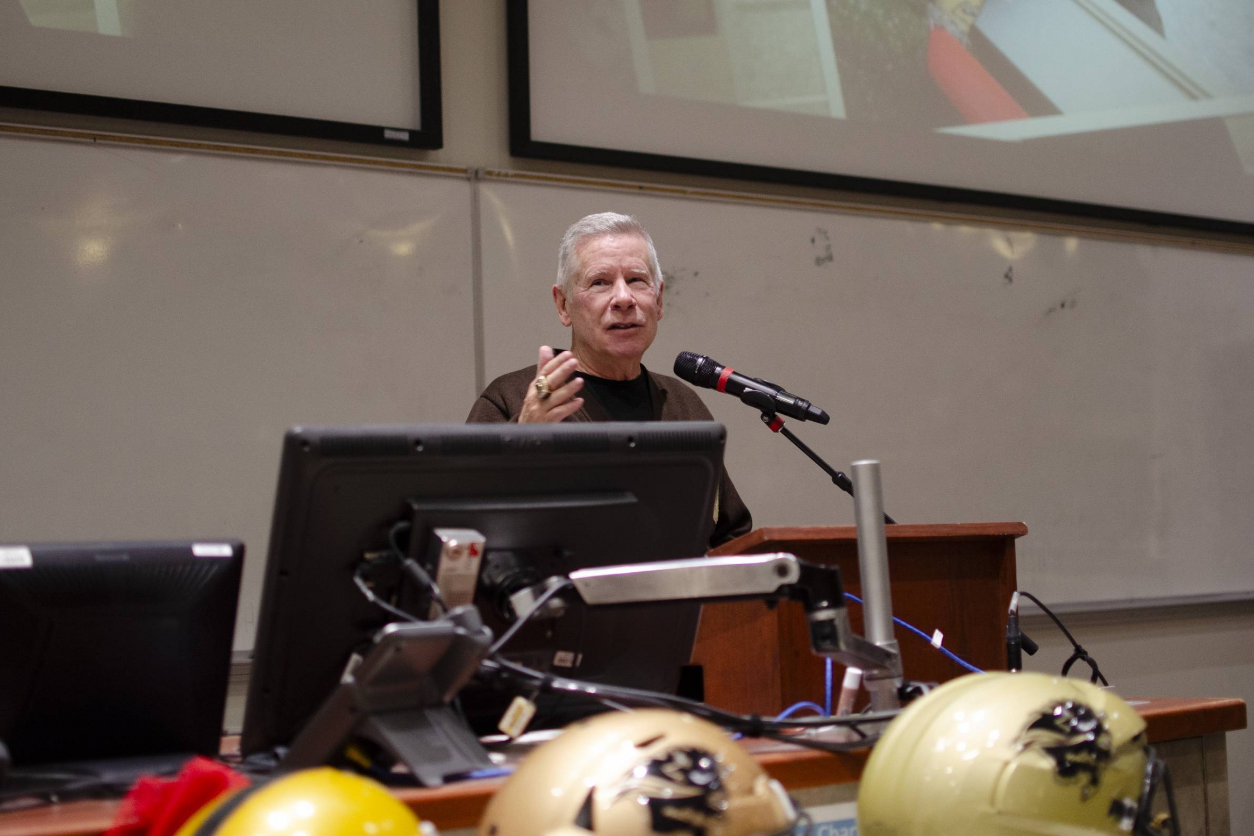 Brian Dobie speaking in front of a podium and microphone