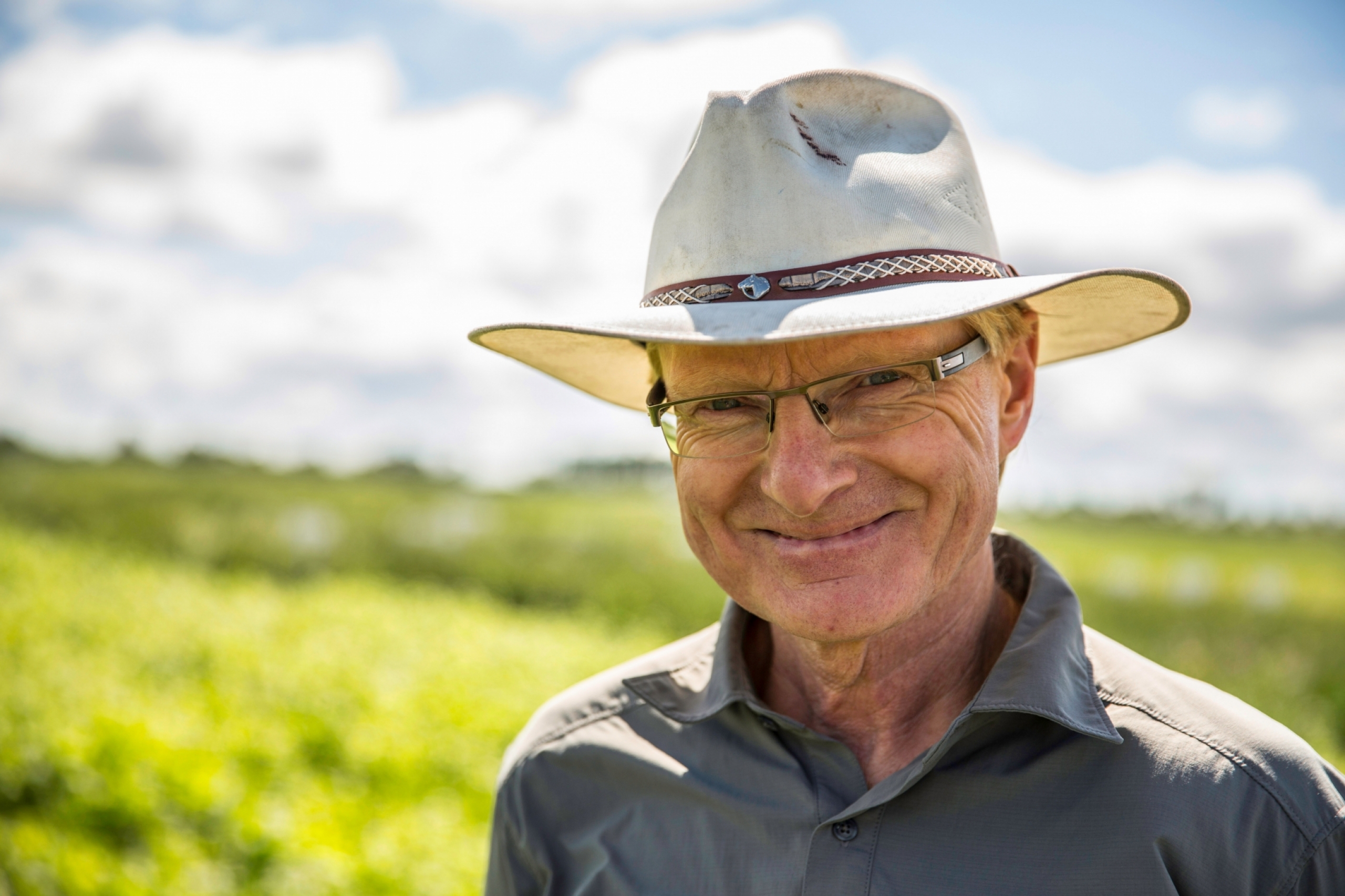 Martin Entz wearing a brimmed hat in a field.