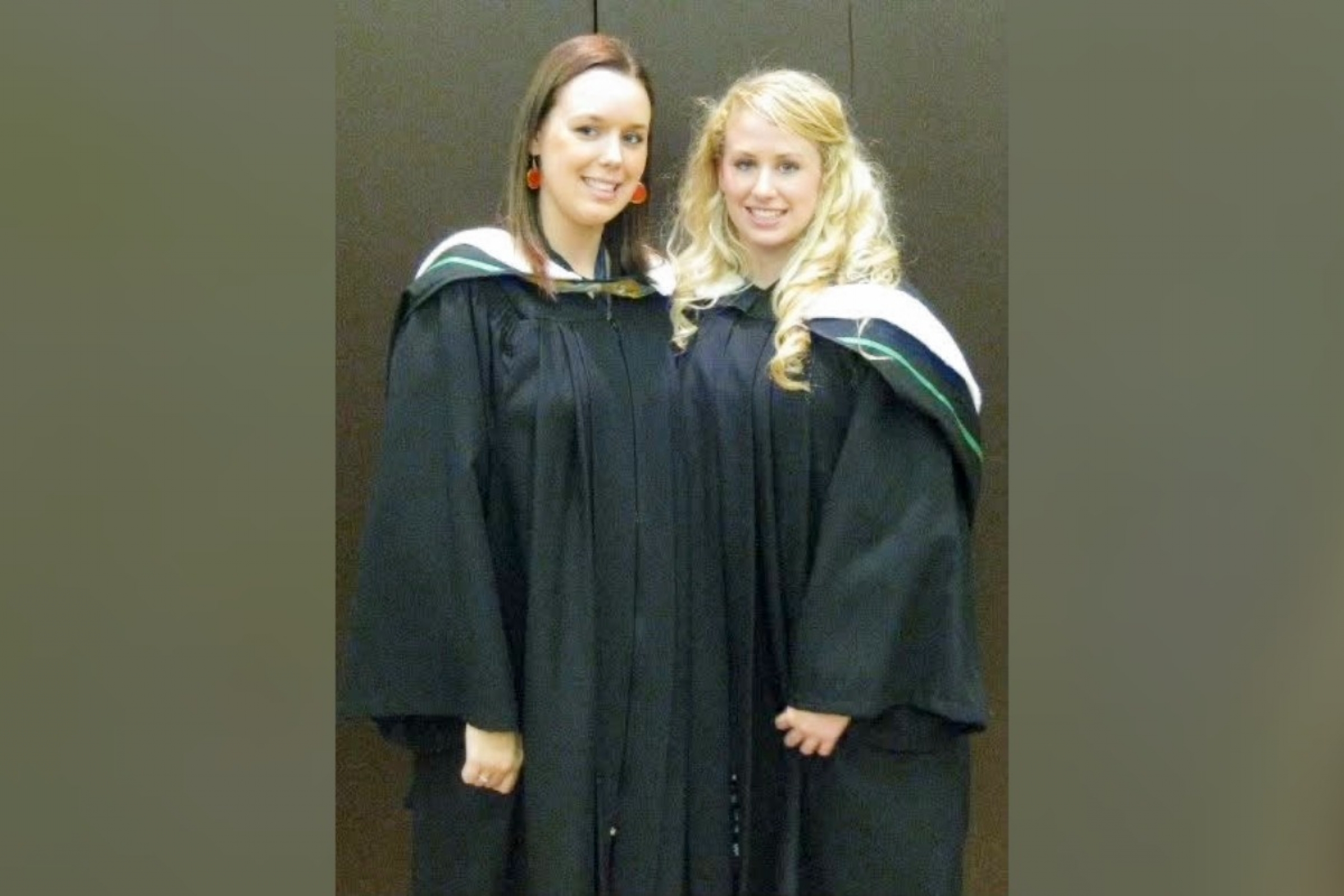Two people wearing graduation robes.