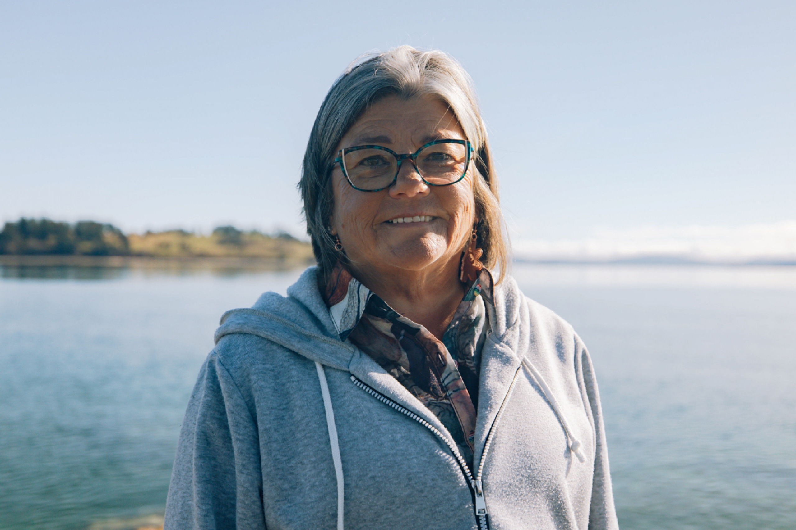 Shannon McDonald smiles at the camera, in the background is an open body of water.