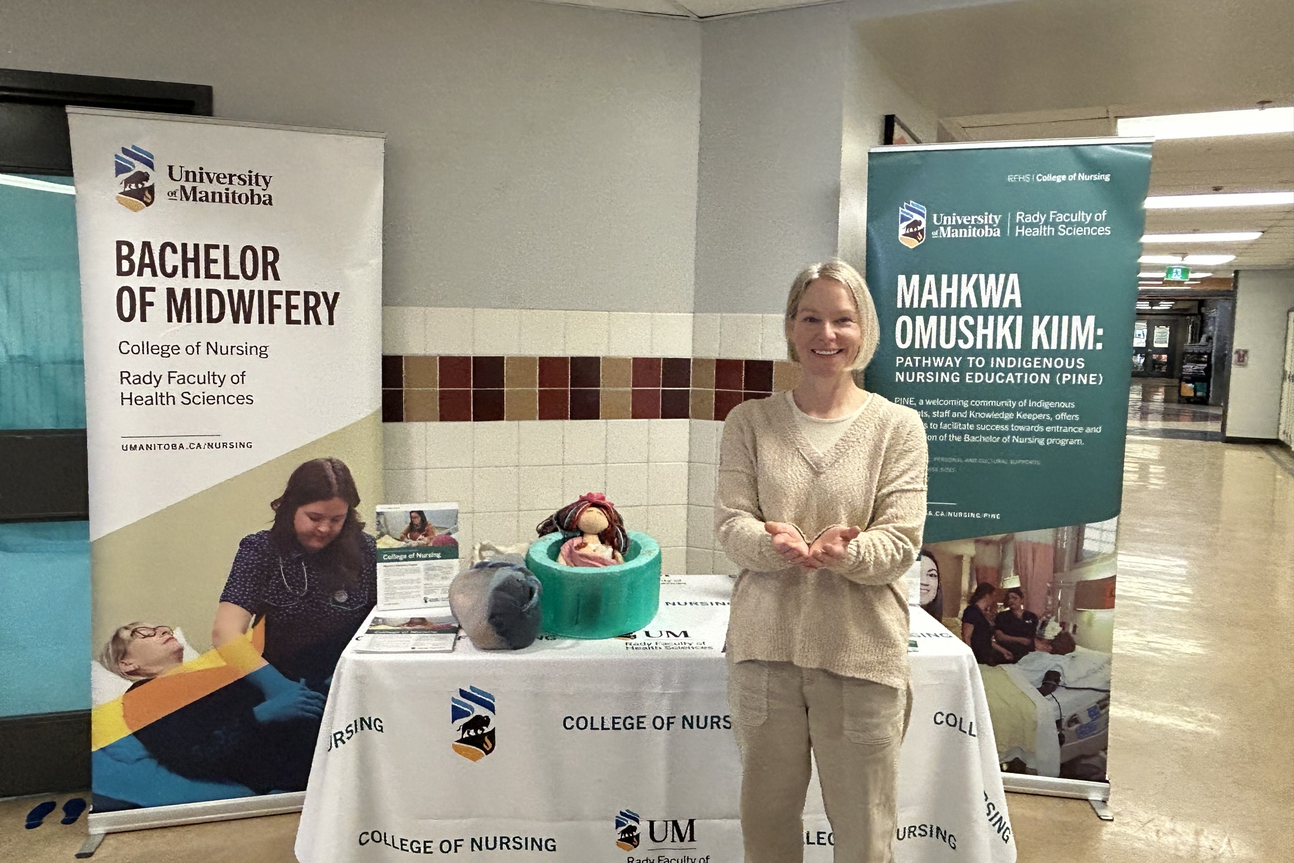 Fleur McEvoy striking the Give to Gain pose in a UM recruitment booth.