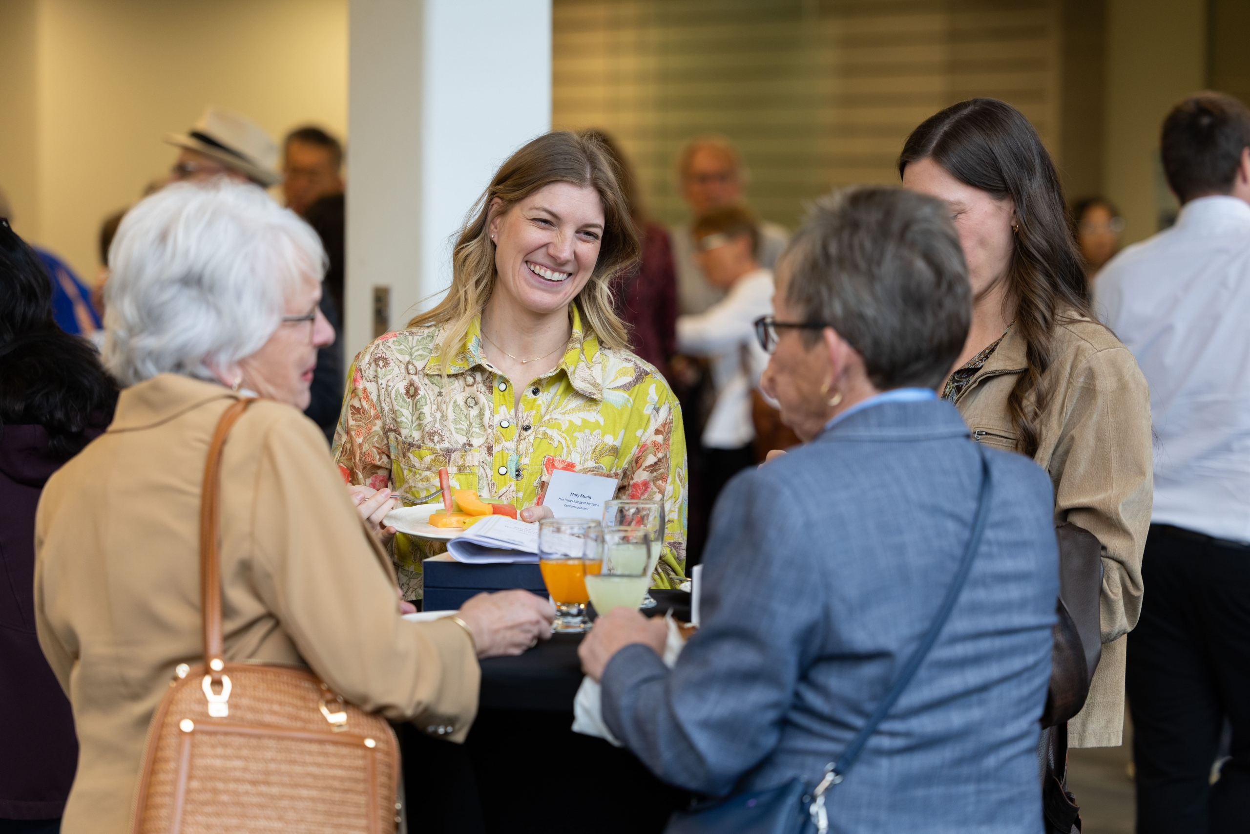 Mary Strain shares a bright smile with other attendees while getting refreshments.
