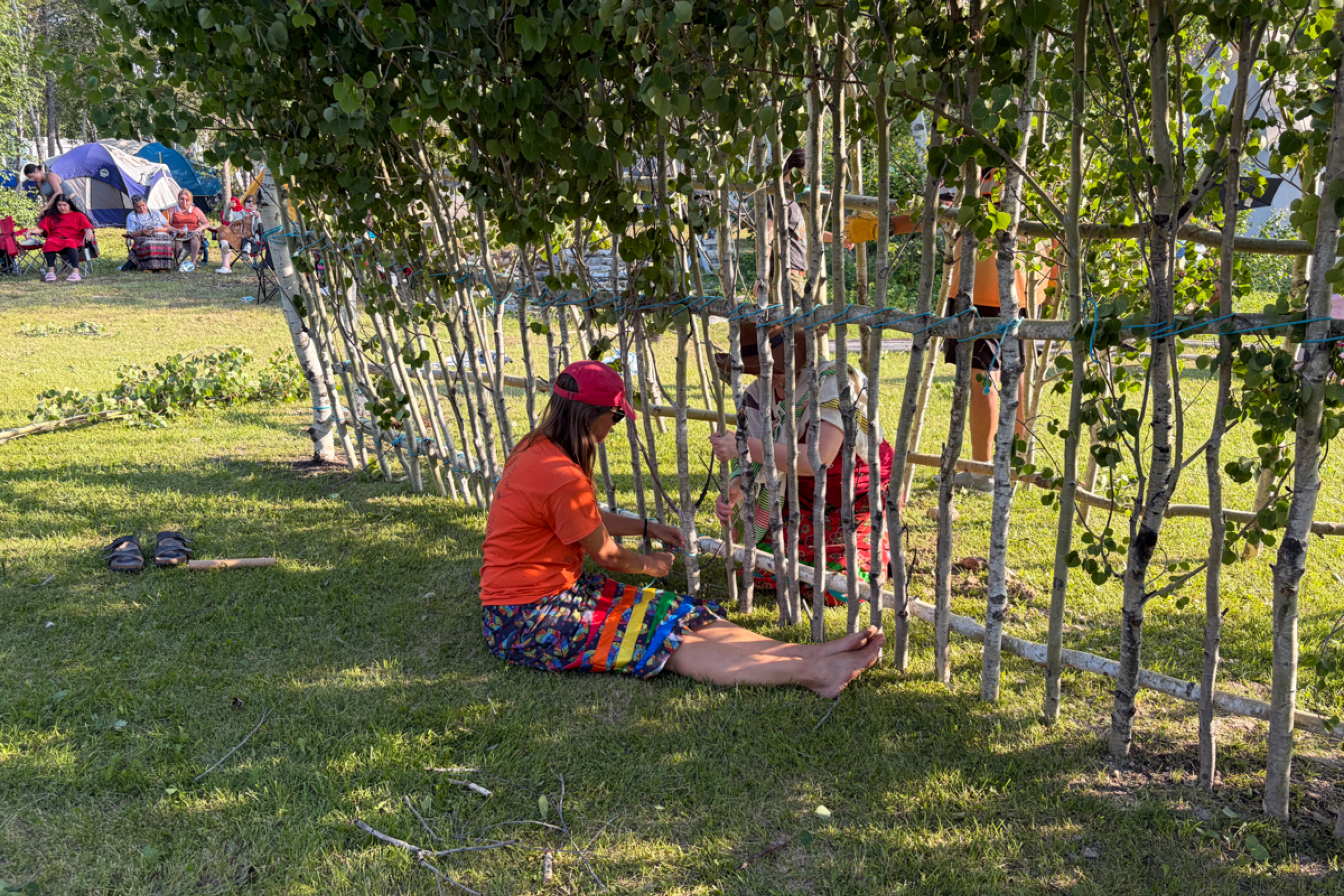 Two people help build a Sundance lodge.