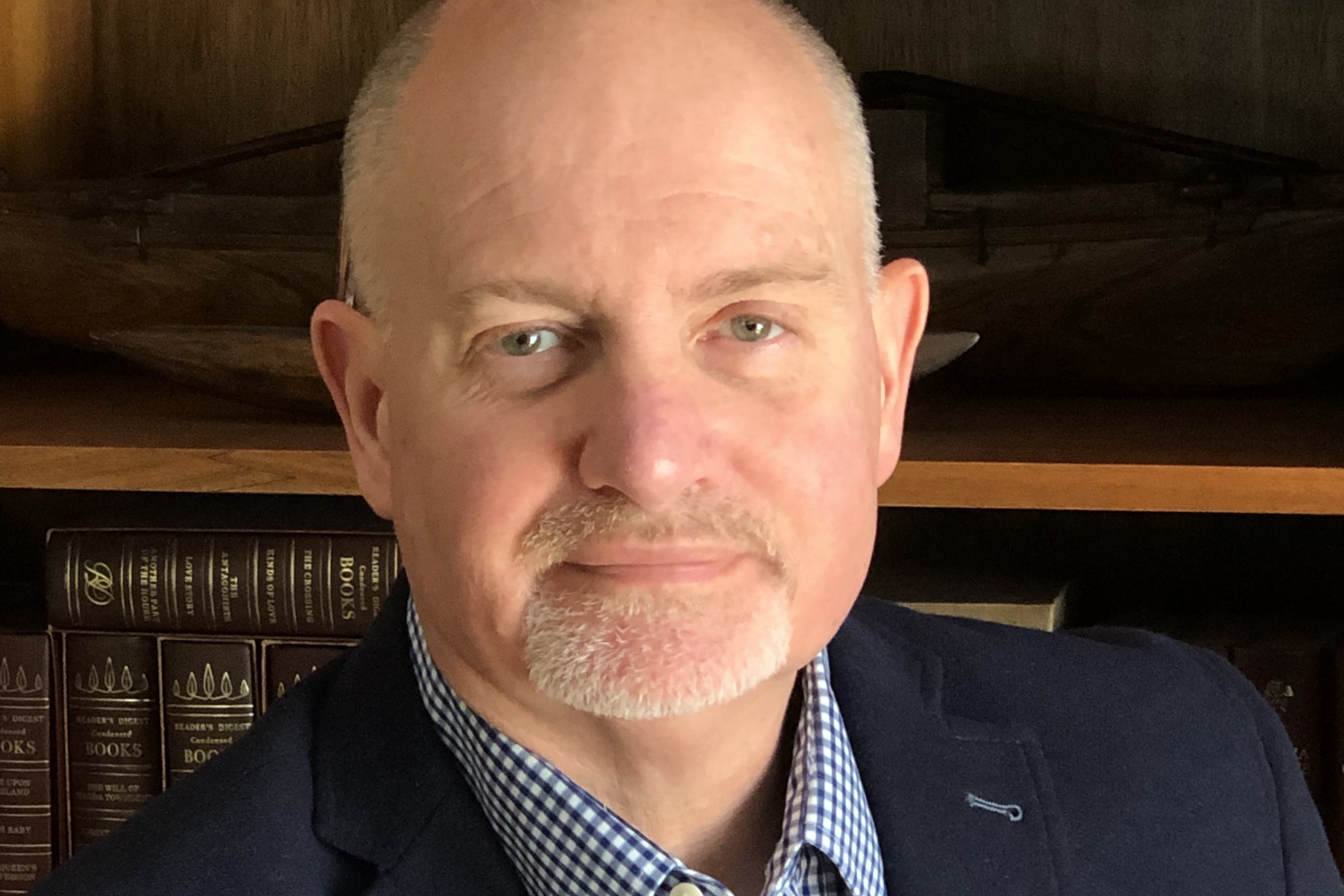 Man sits before bookcase