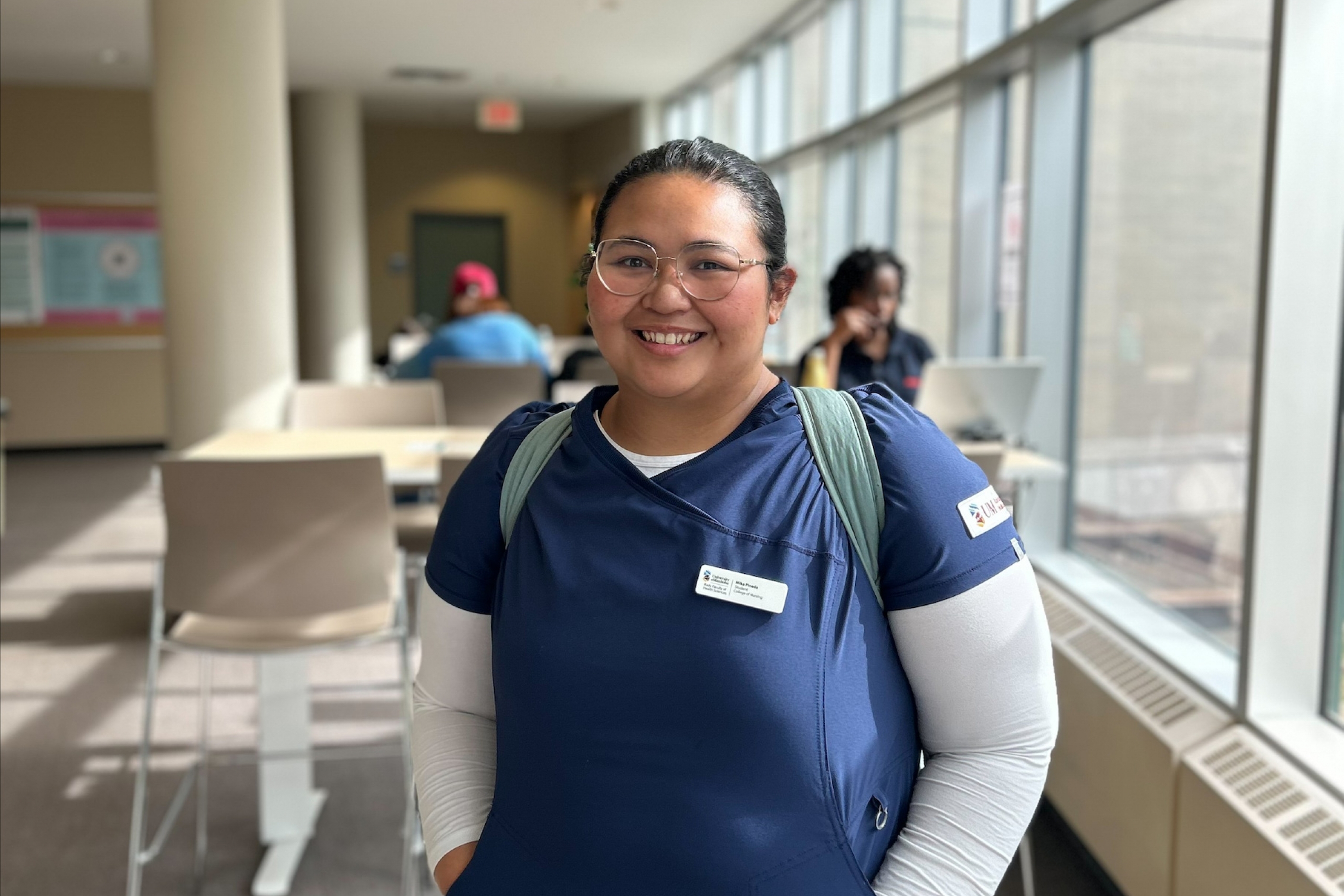 Mika Pineda standing in the Helen Glass Centre for Nursing at Fort Garry Campus. 