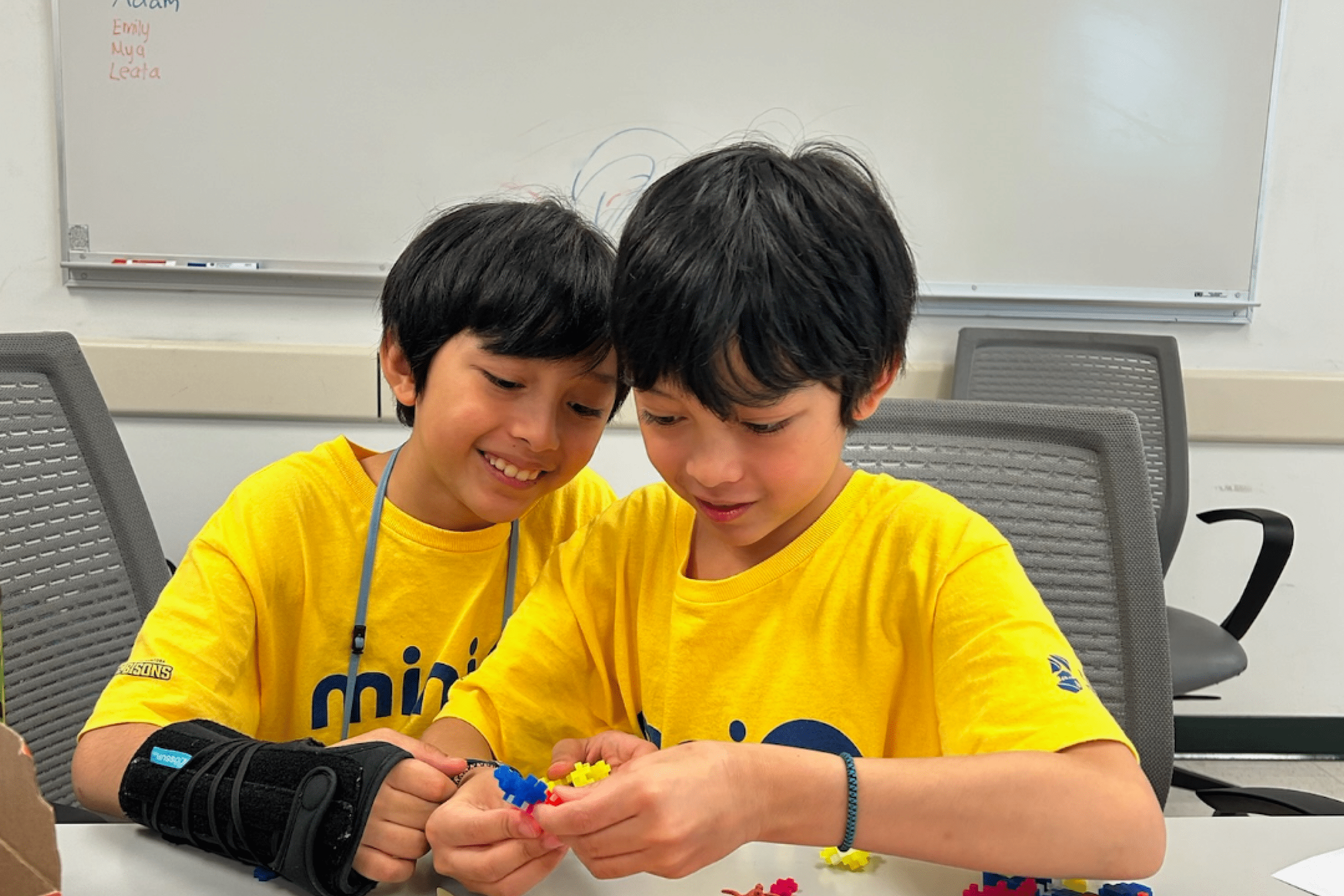 Two children working with building blocks at a table.
