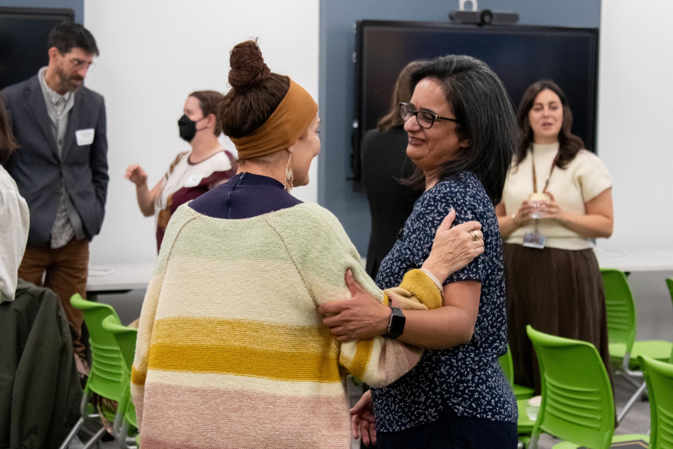Two women cross arms as they celebrate the completion of the TLC program.