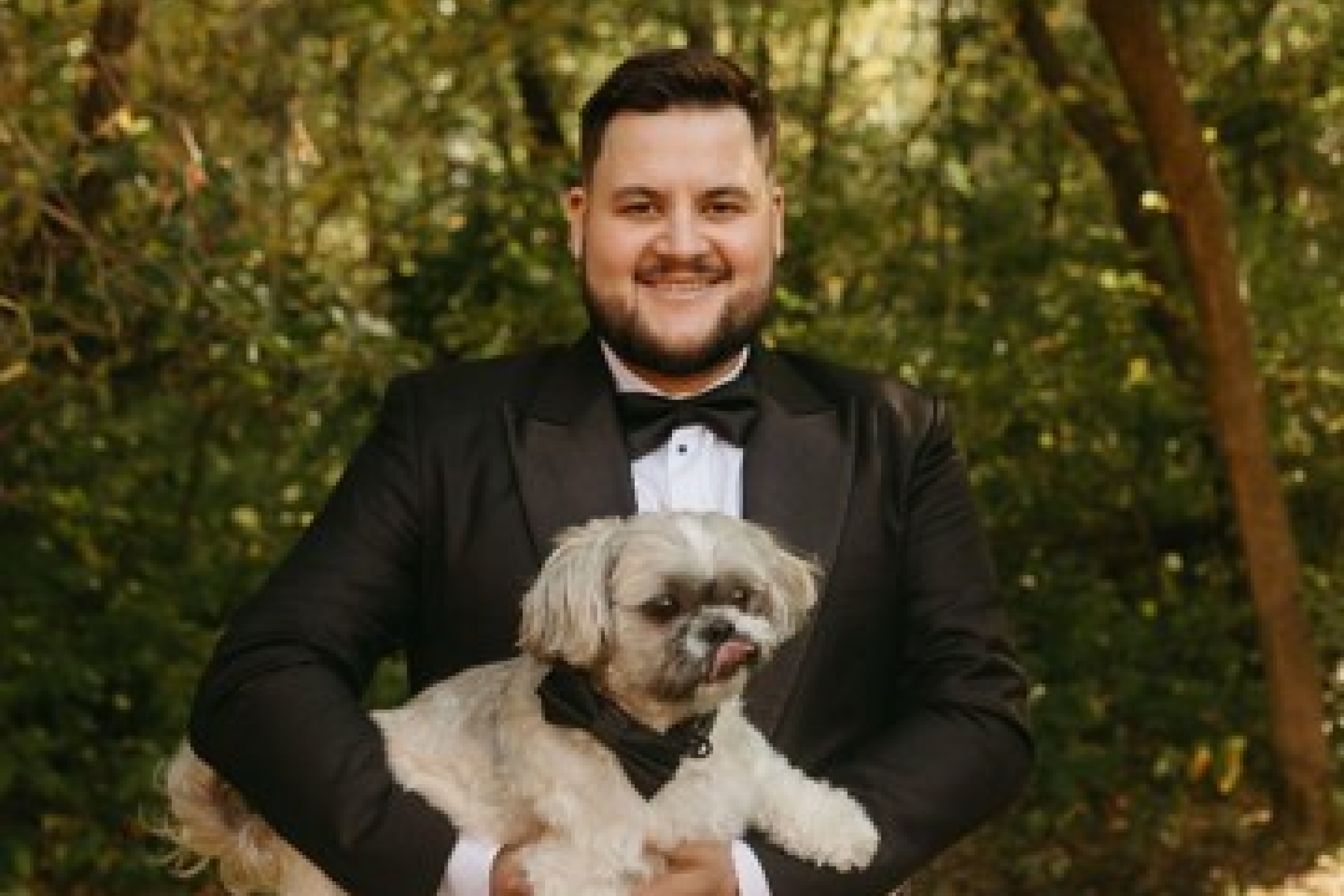 A person holding a dog in the woods