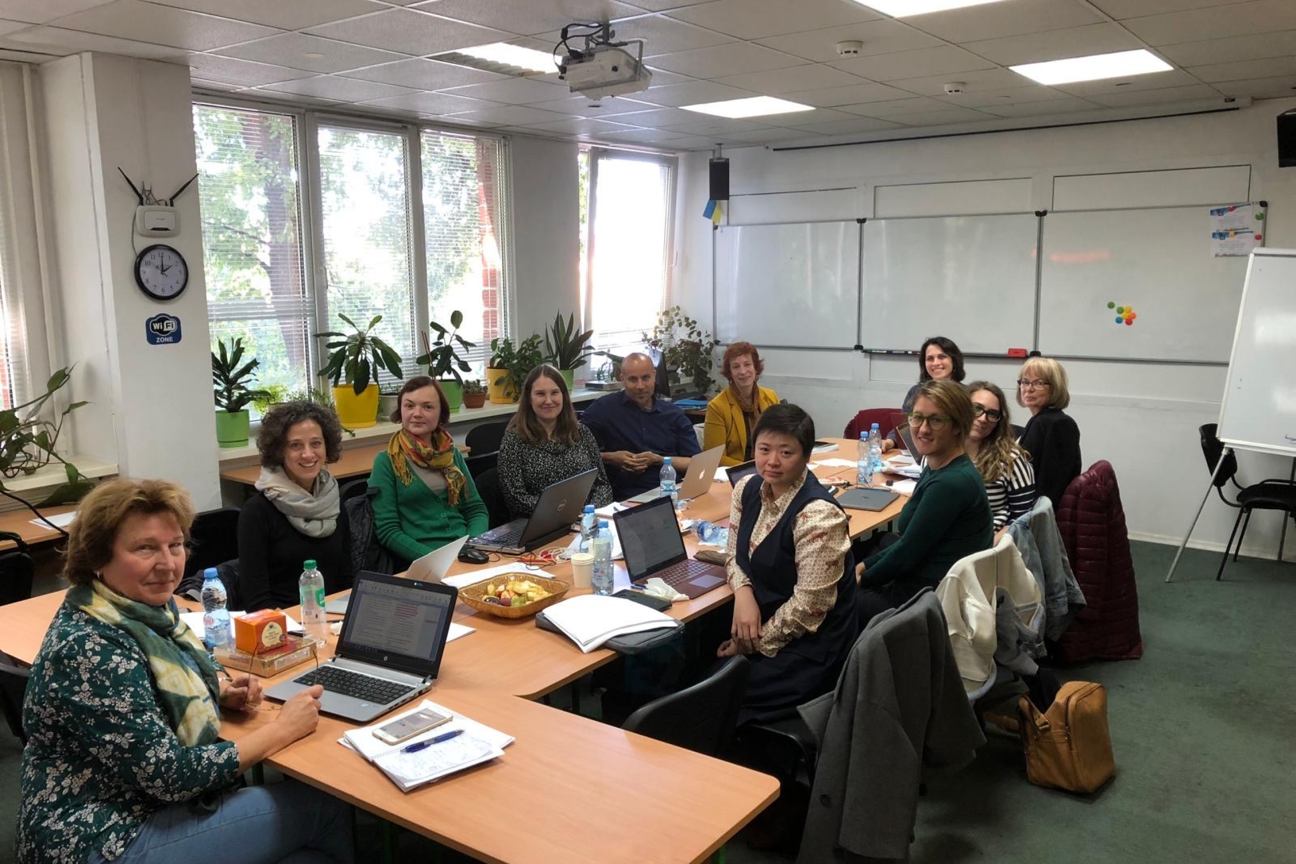 A group of people sitting at a table and smiling at the camera.