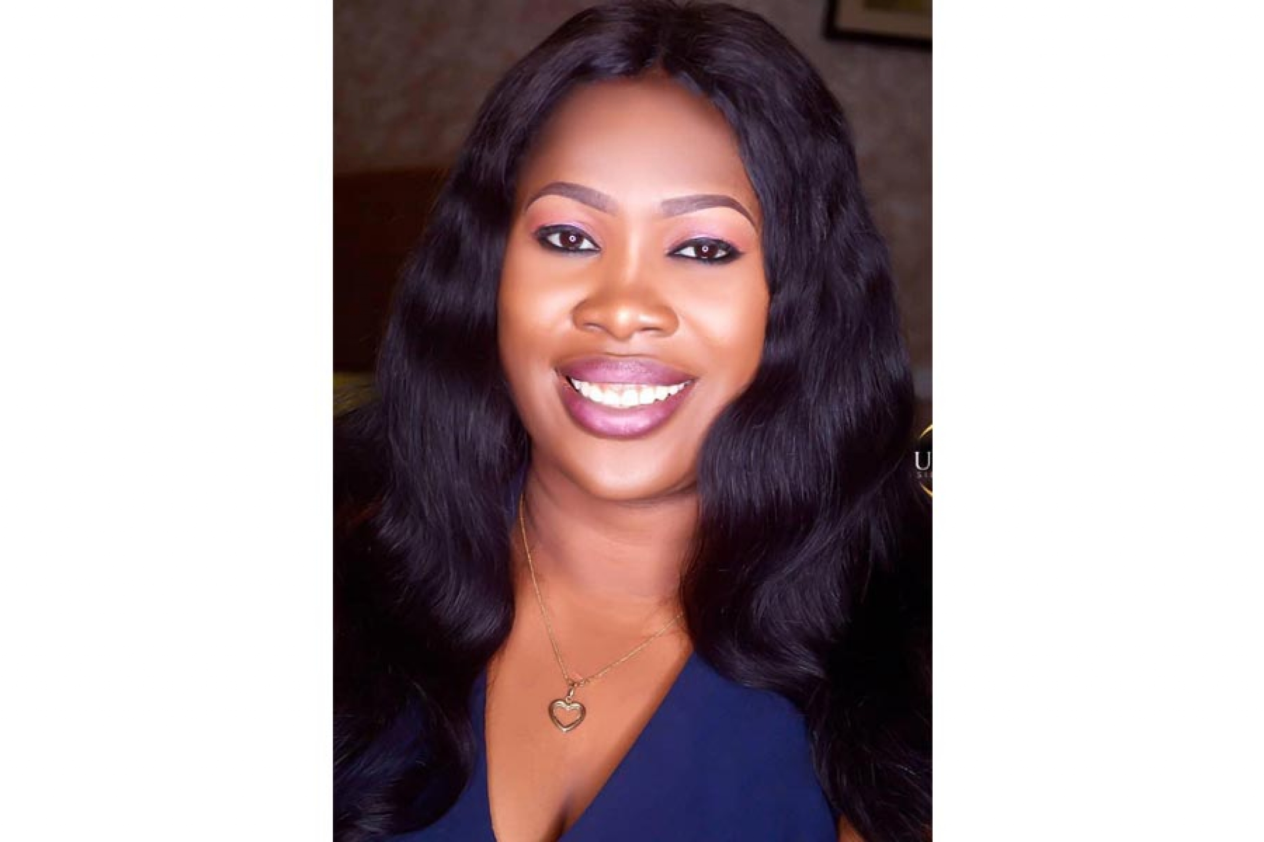 Woman with long black hair wearing a blue v-neck shirt