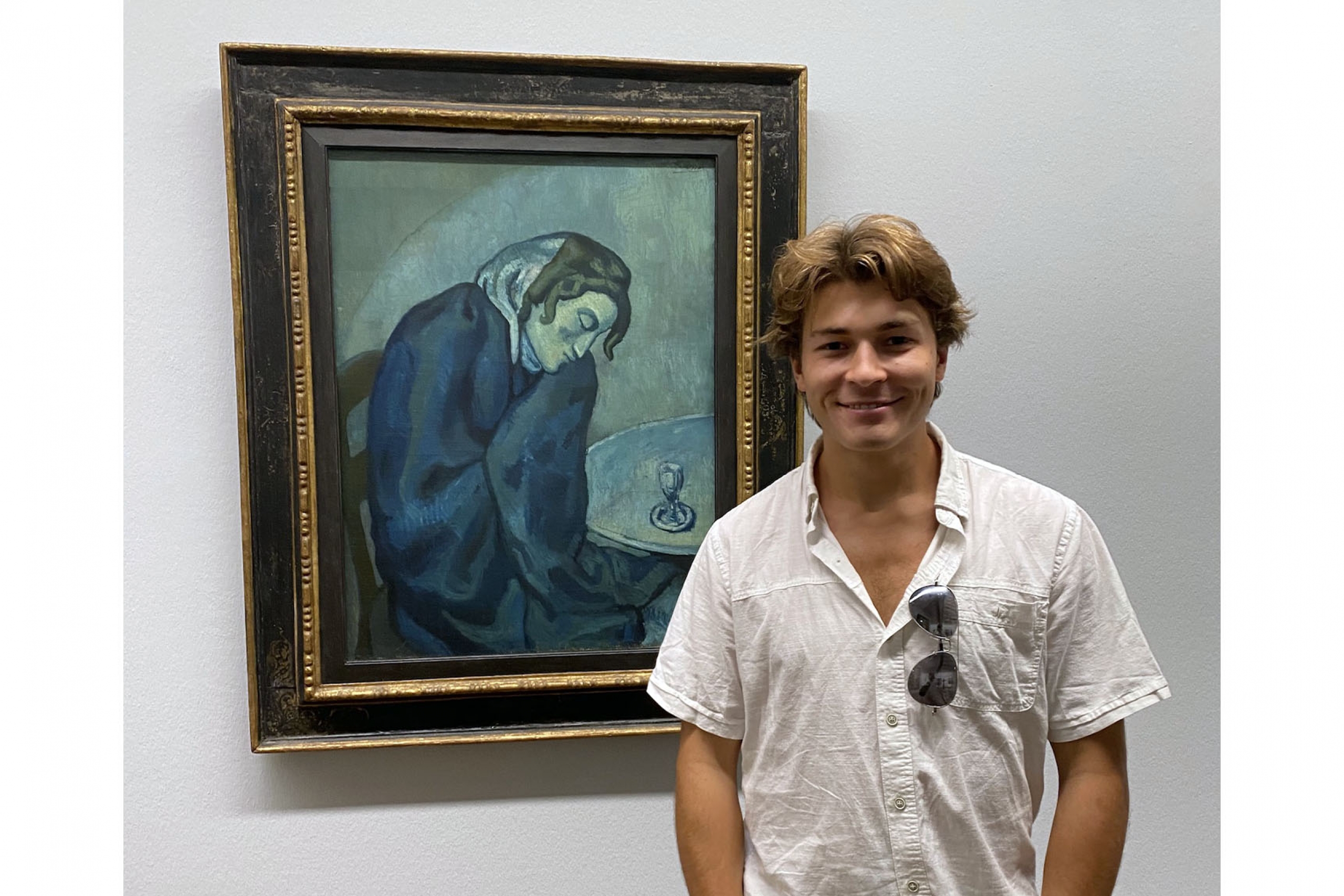 Person standing in front of an old painting in a museum.