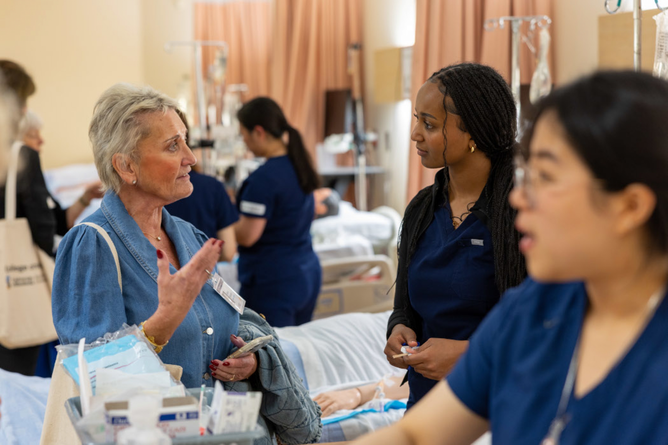 A nursing alum speaks with a nursing student. 