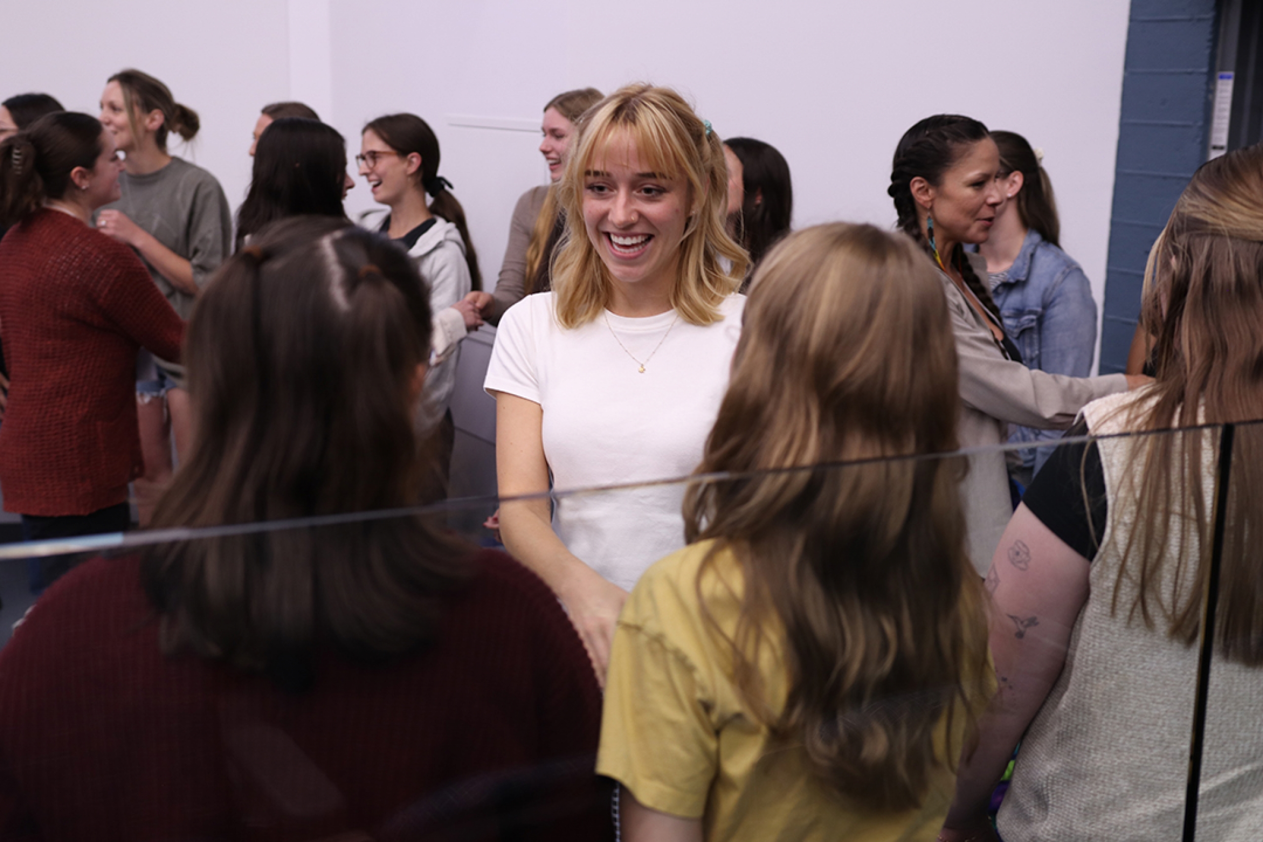 A smiling student shakes hands with other students in a line.