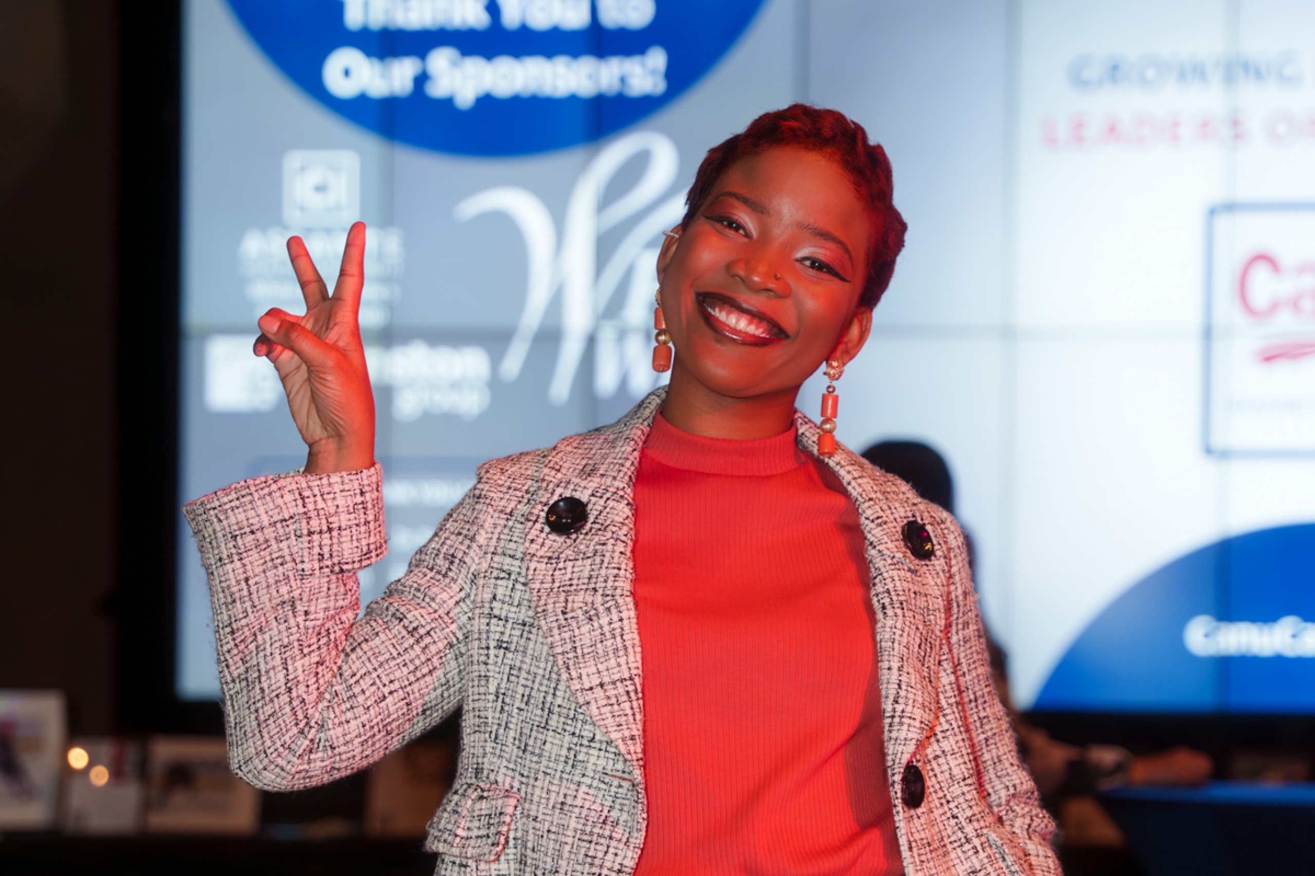 Olivia Obilo-Josiah strikes a peace sign as she smiles at the camera.