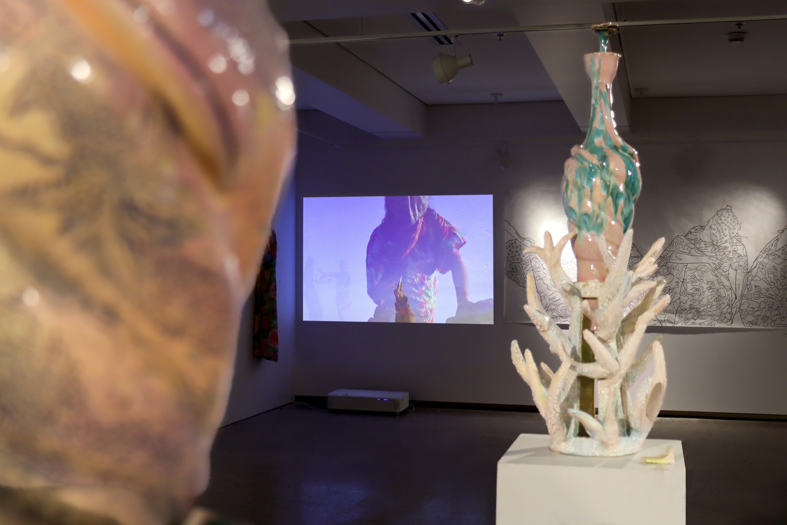 Ceramic sculpture with video projection in gallery background