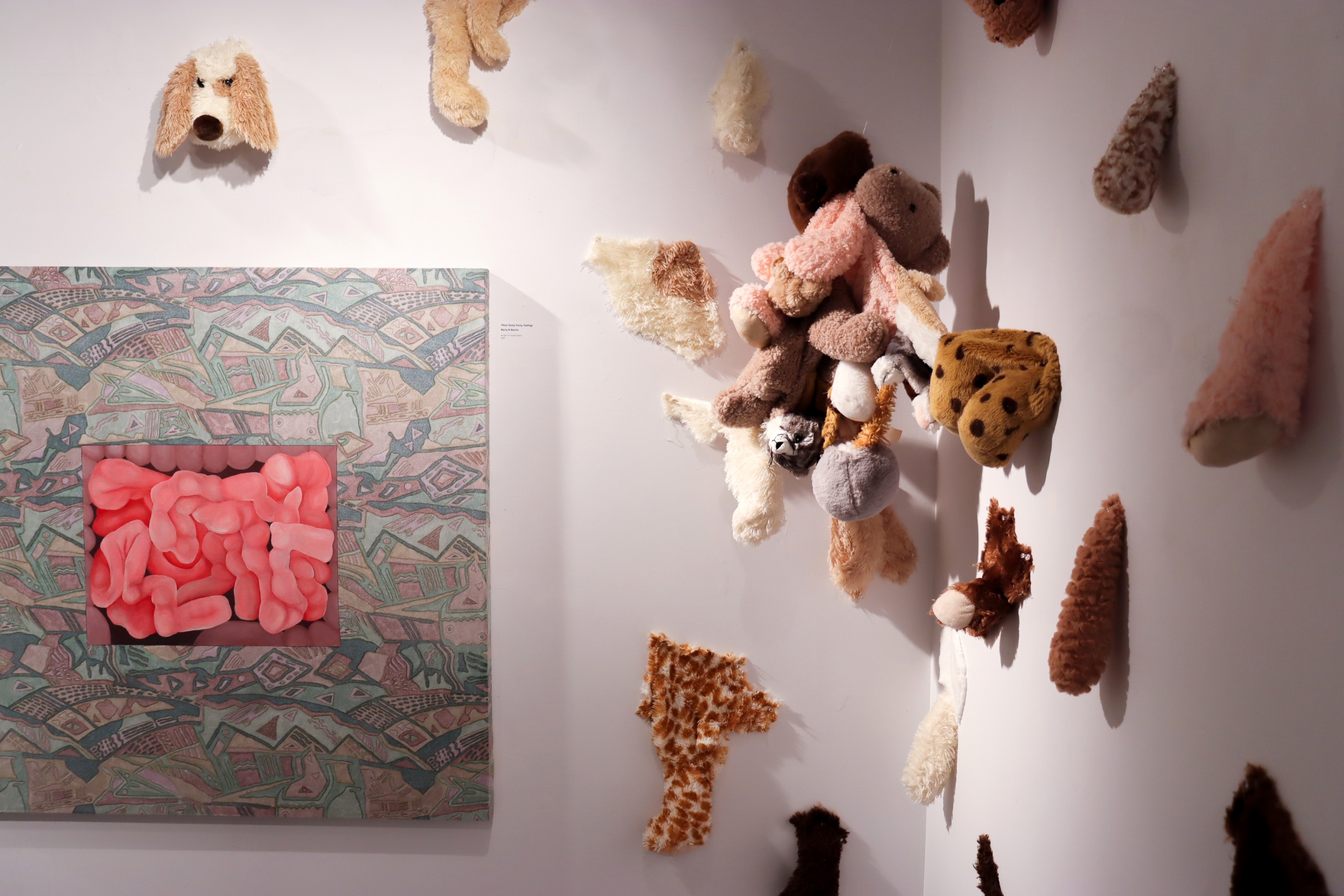 Plush material installation with clustered soft forms on wall