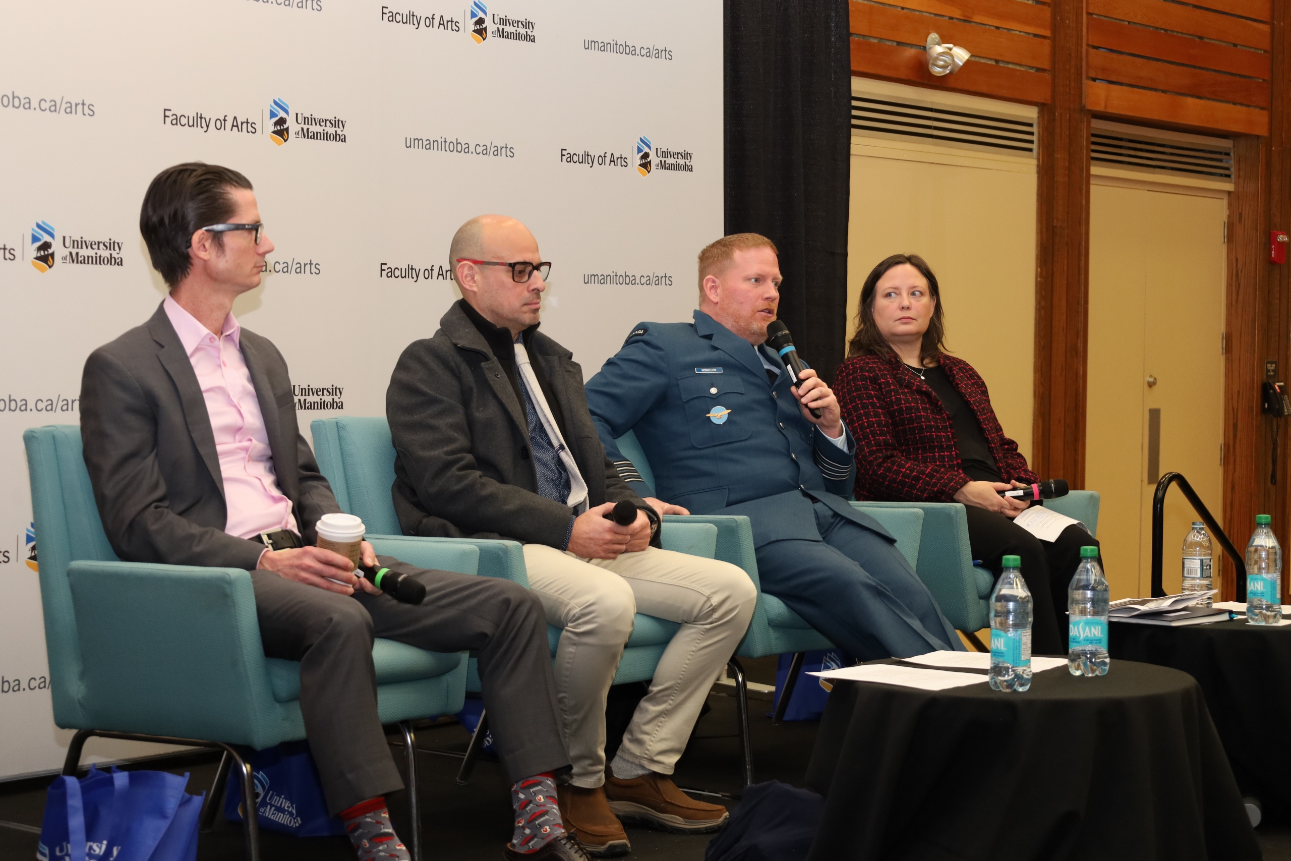 Four people sitting on a stage, panel style. 