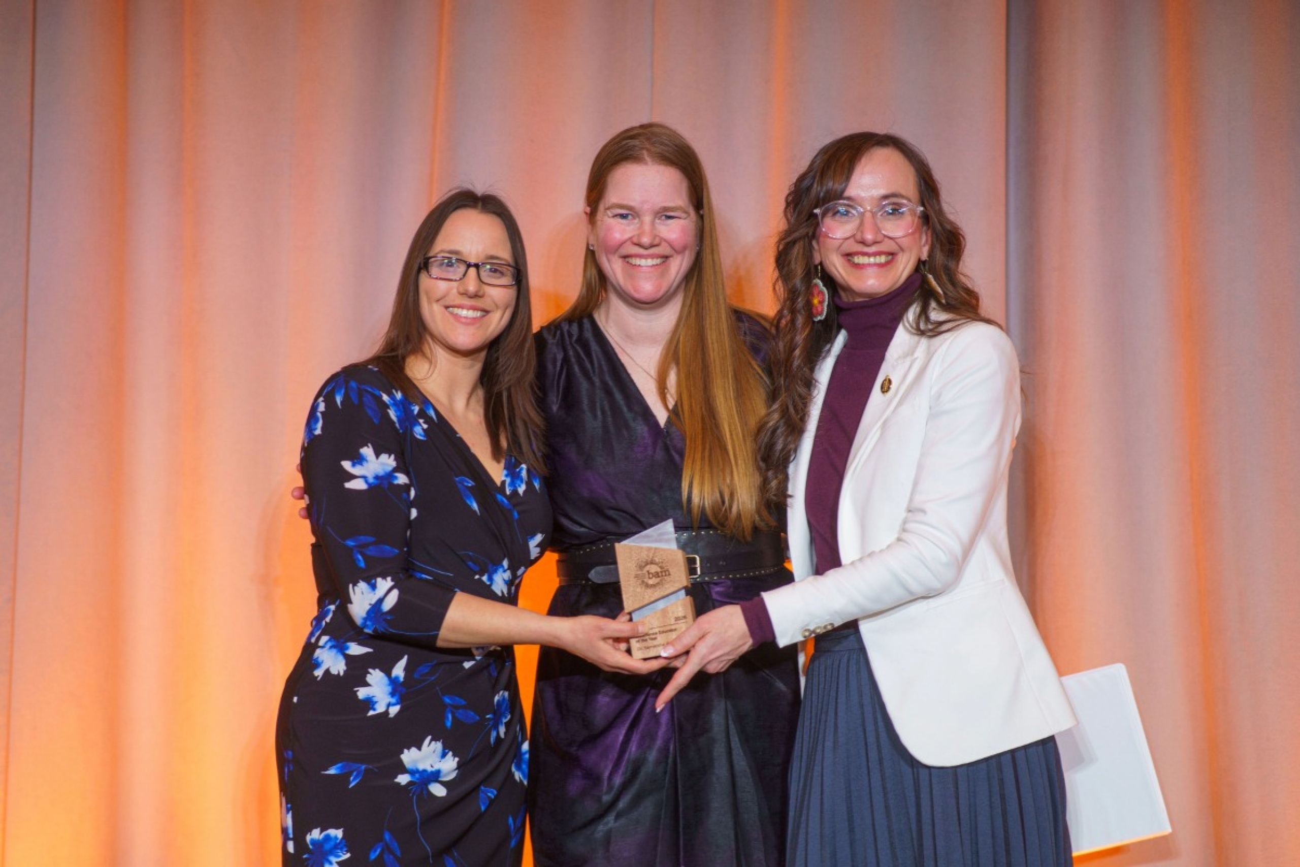 Three people holding an award.