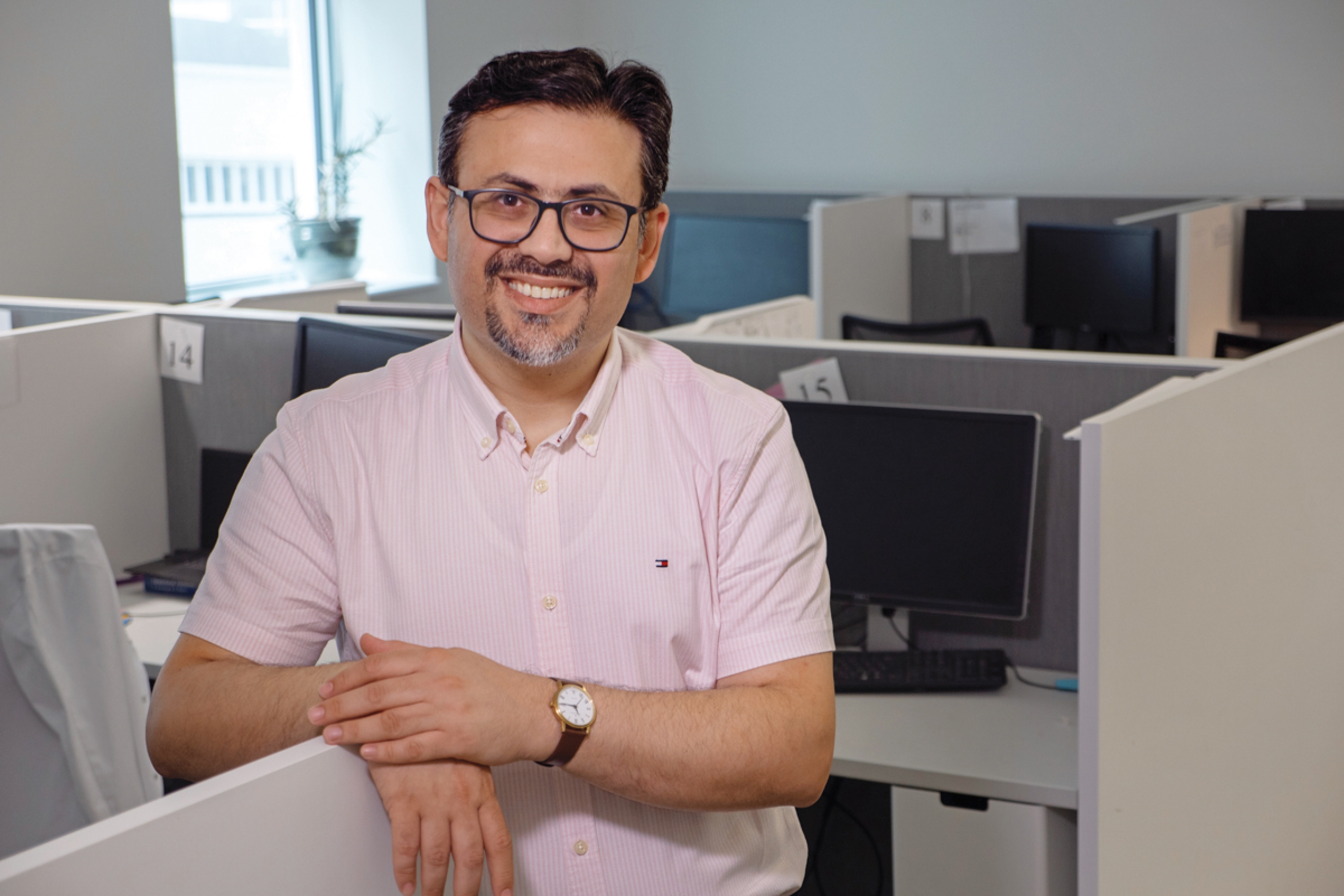 A person smiles for the camera in a computer room.