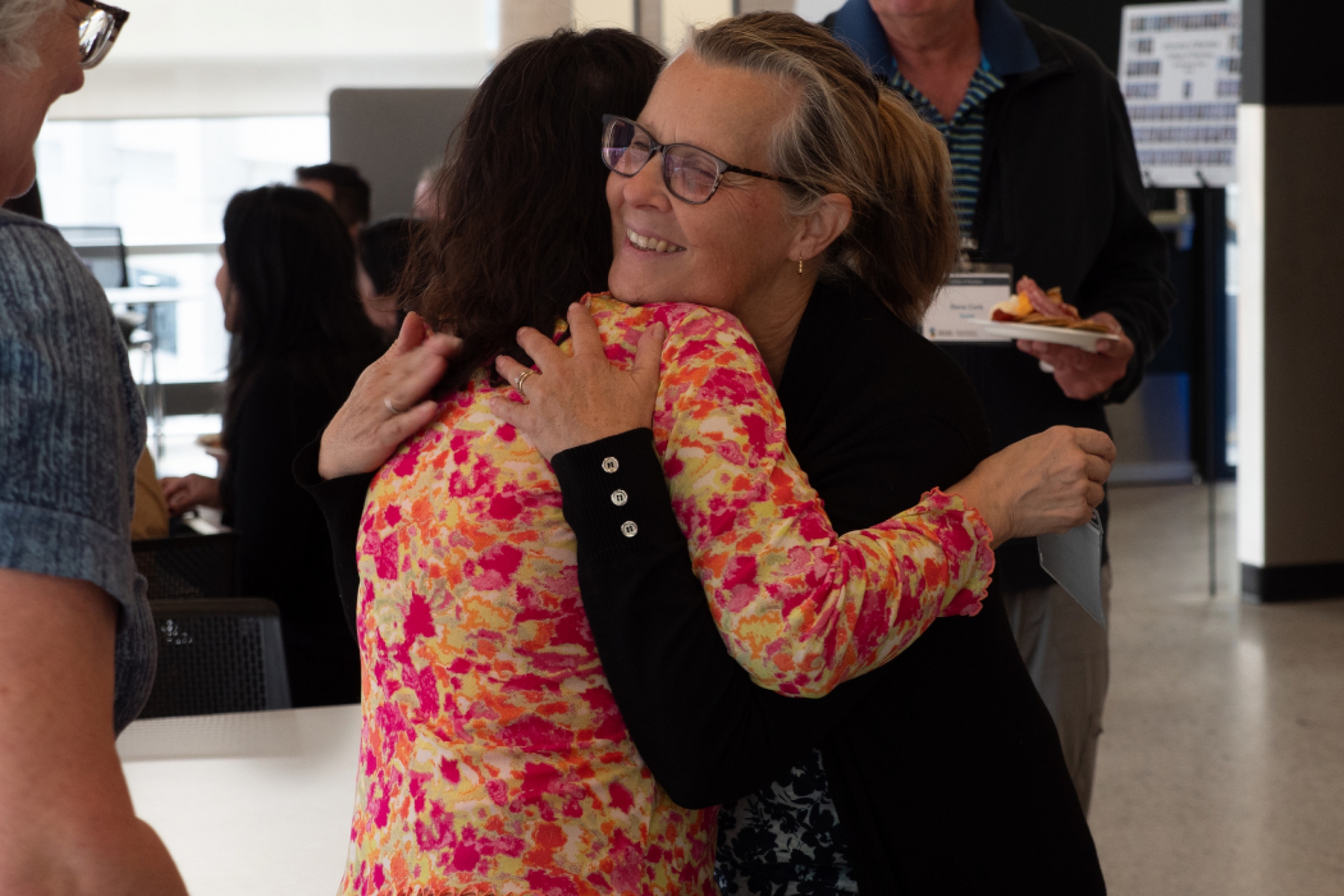 Two pharmacy alumni hug. 