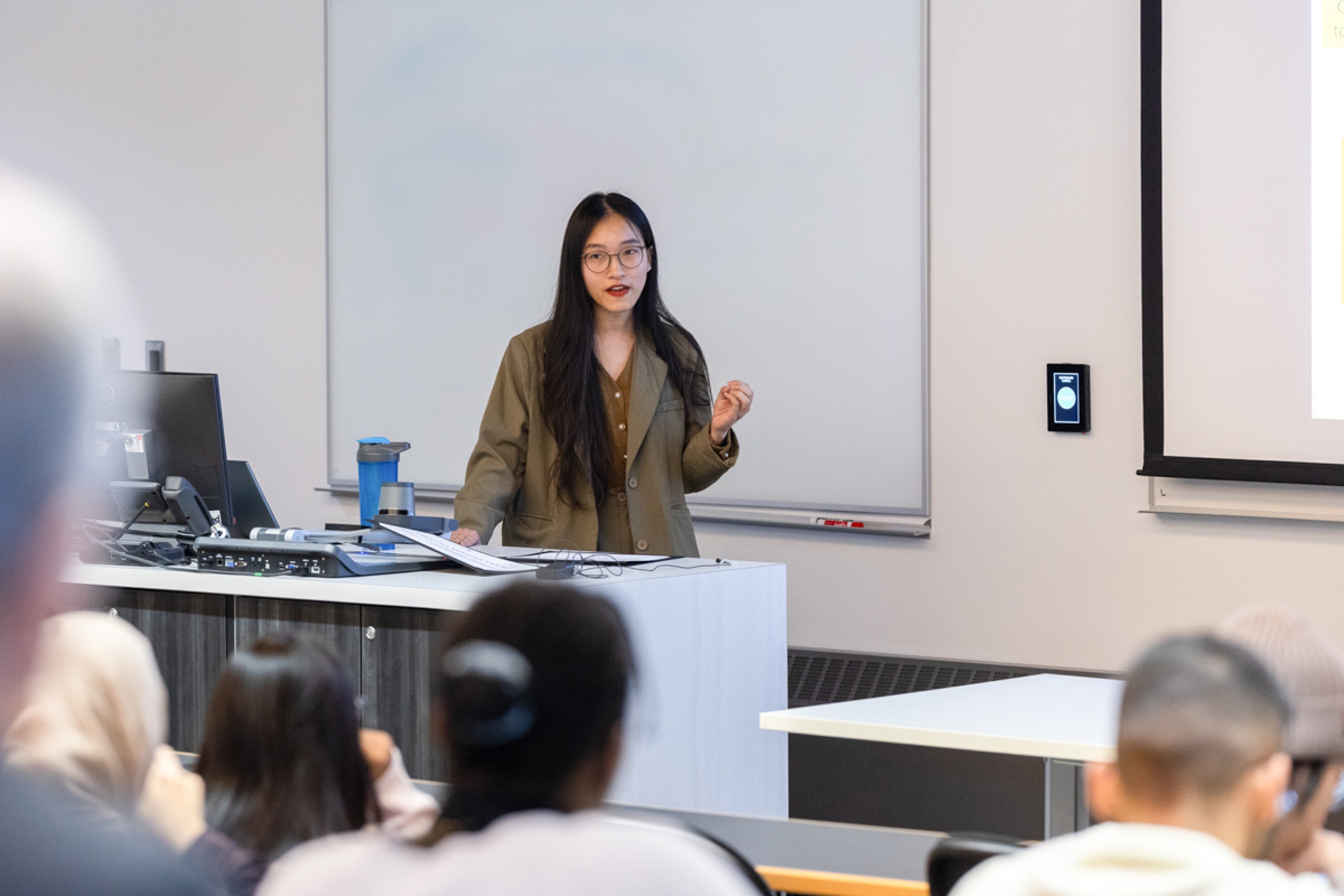 A student presenting their research to a crowd.