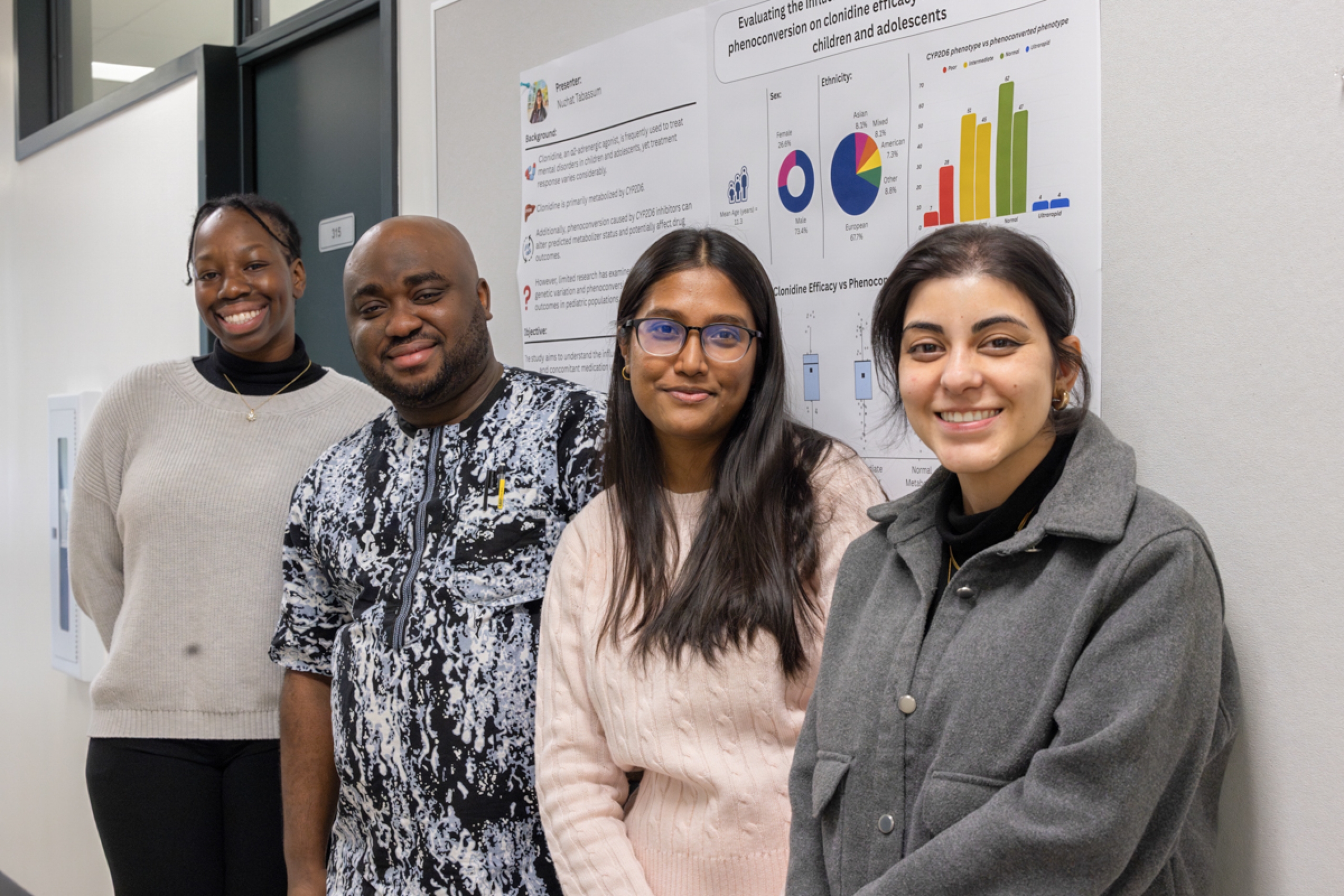 Four students smile at the camera.