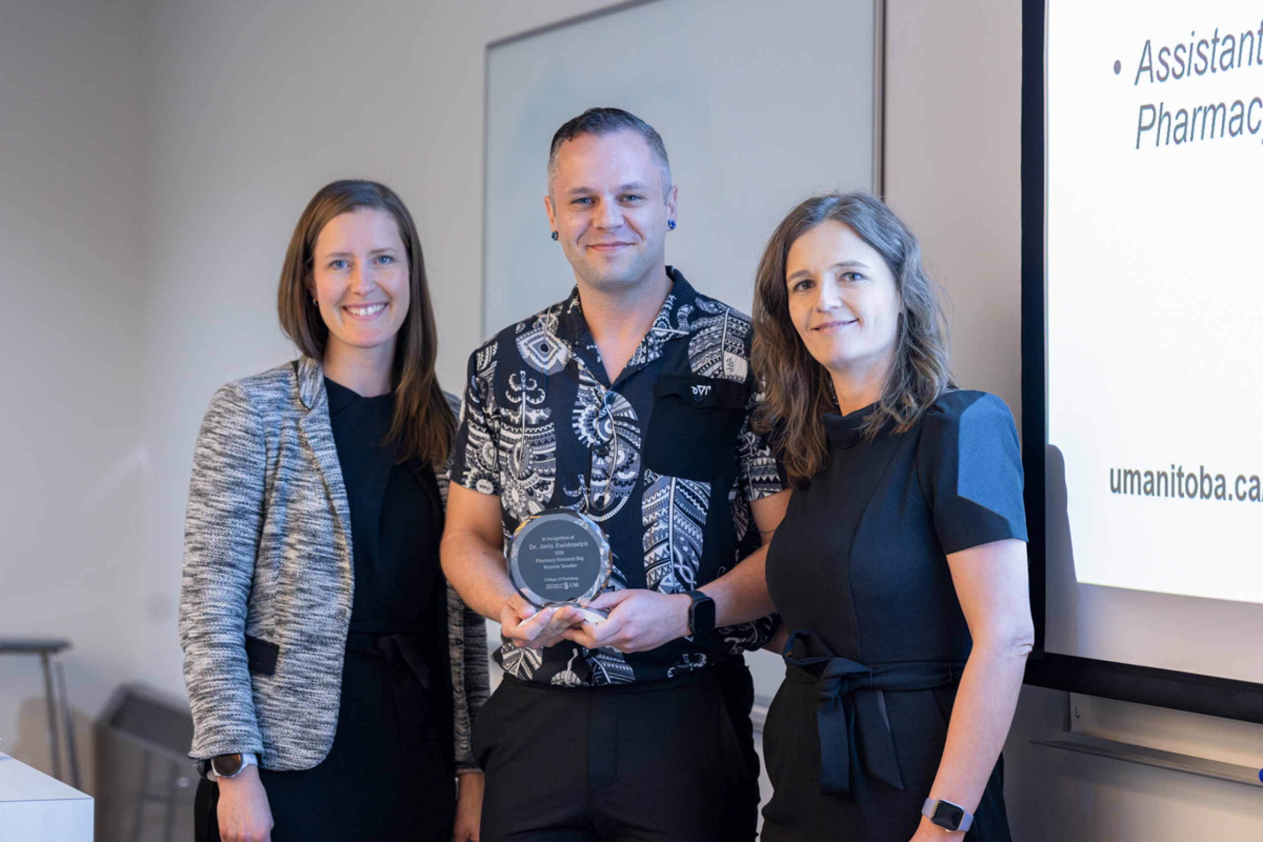 Three people smile at the camera.