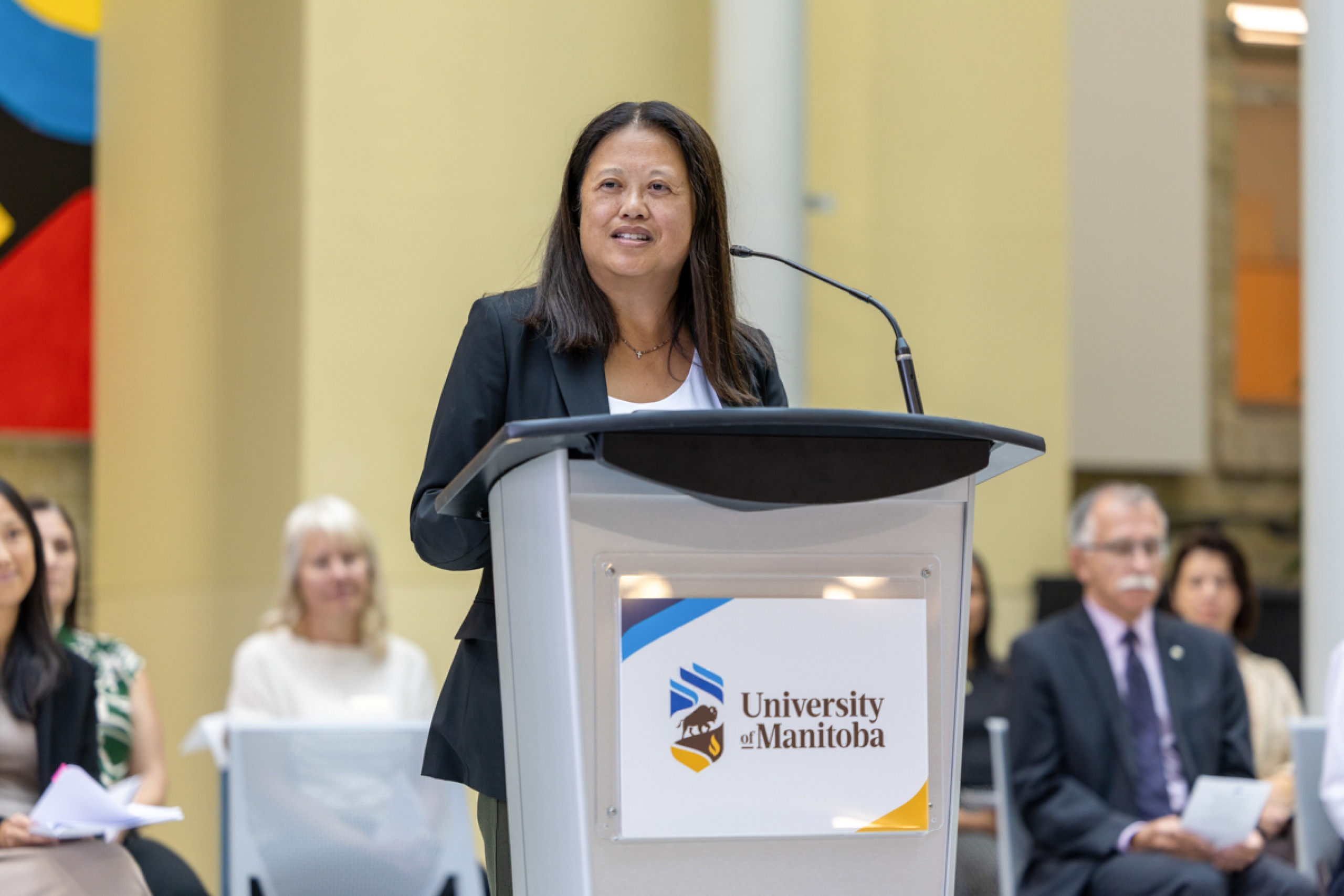 A person speaking at a podium onstage.