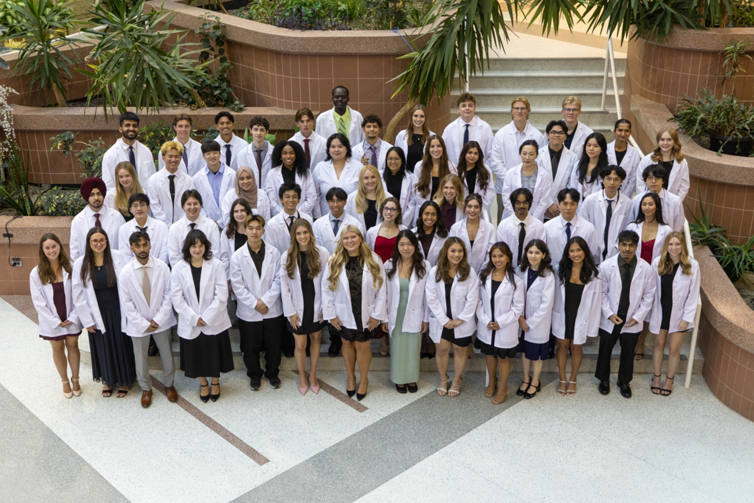 Class photo of students wearing white coats.