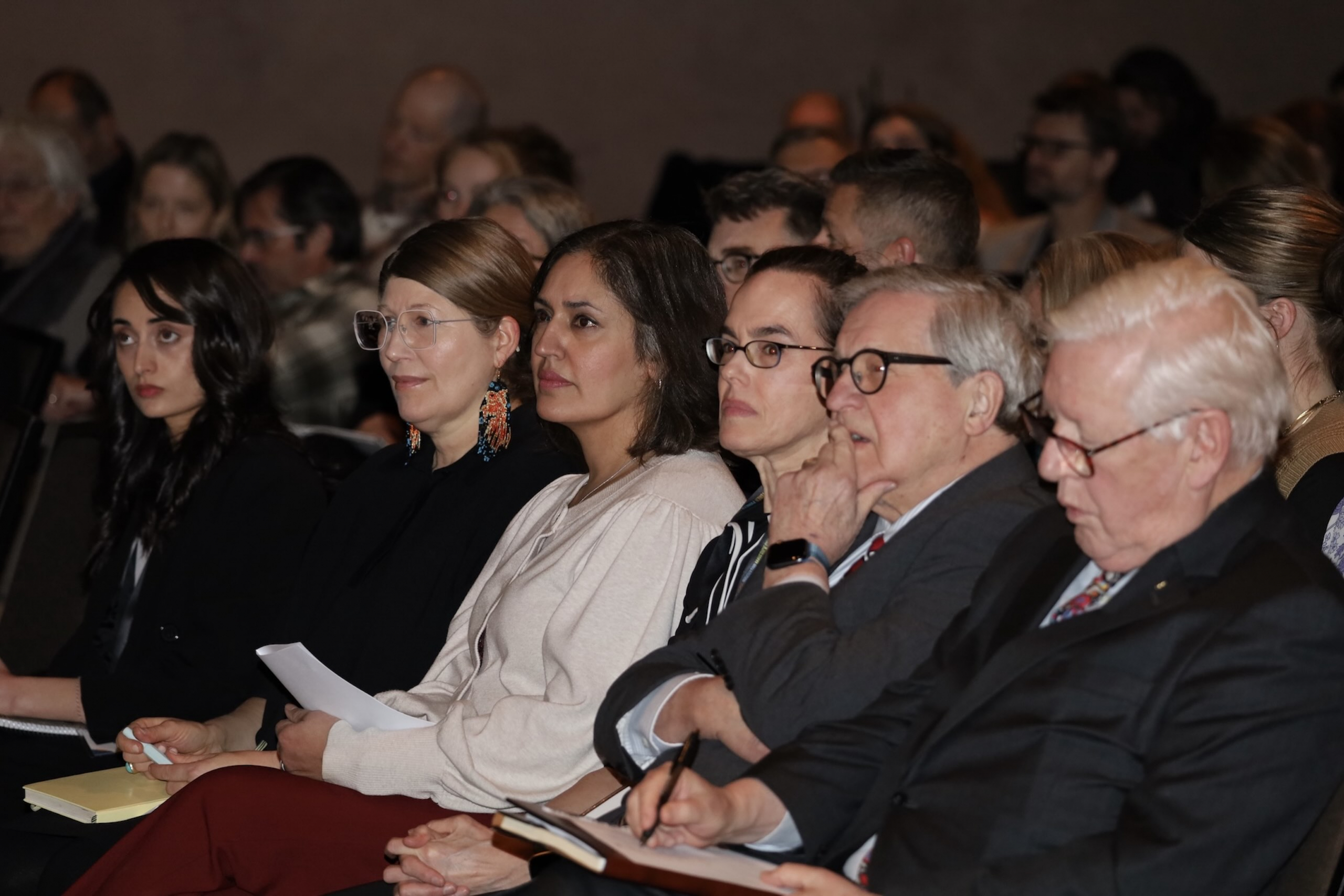 Seated rows of people listening to a speaker.