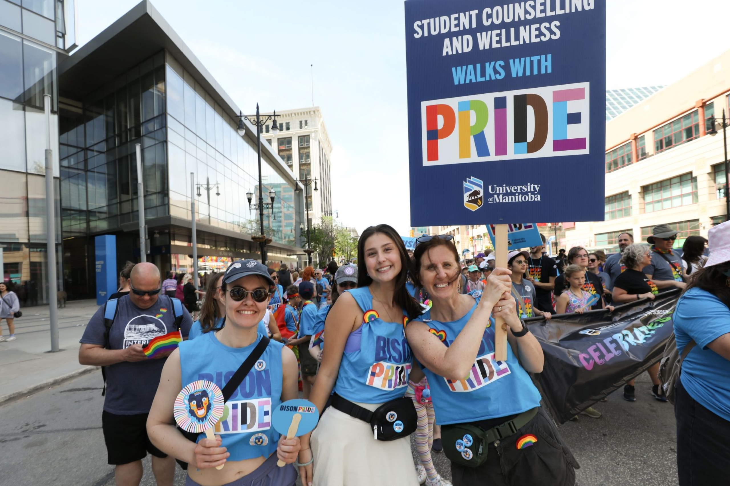 UM community members walking in Pride Winnipeg Parade, carrying banners and signs.