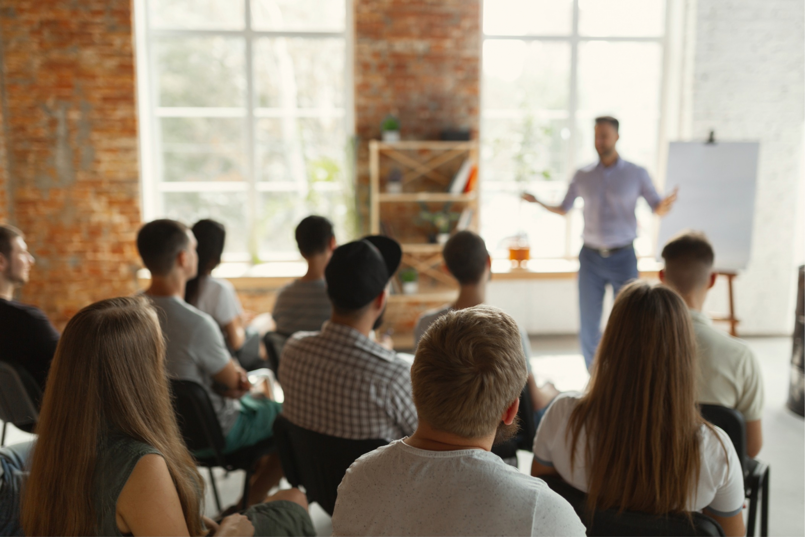 group of people sitting, listening to a speaker