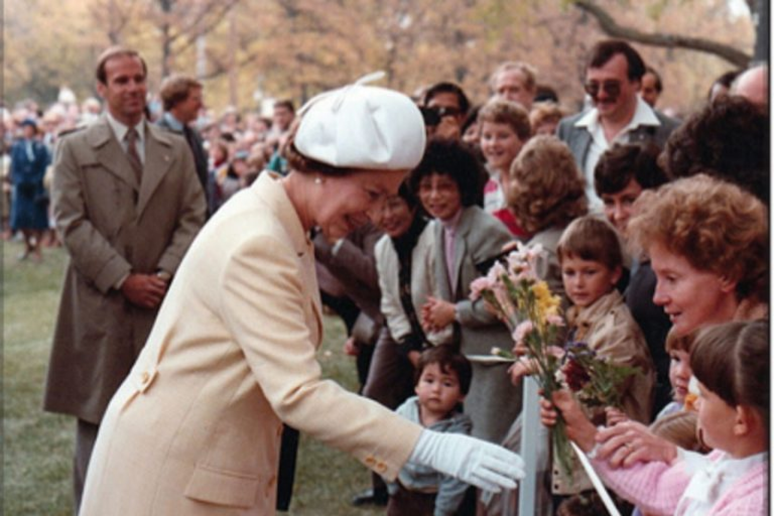 Queen Elizabeth interacts with a crowd behind a barrier