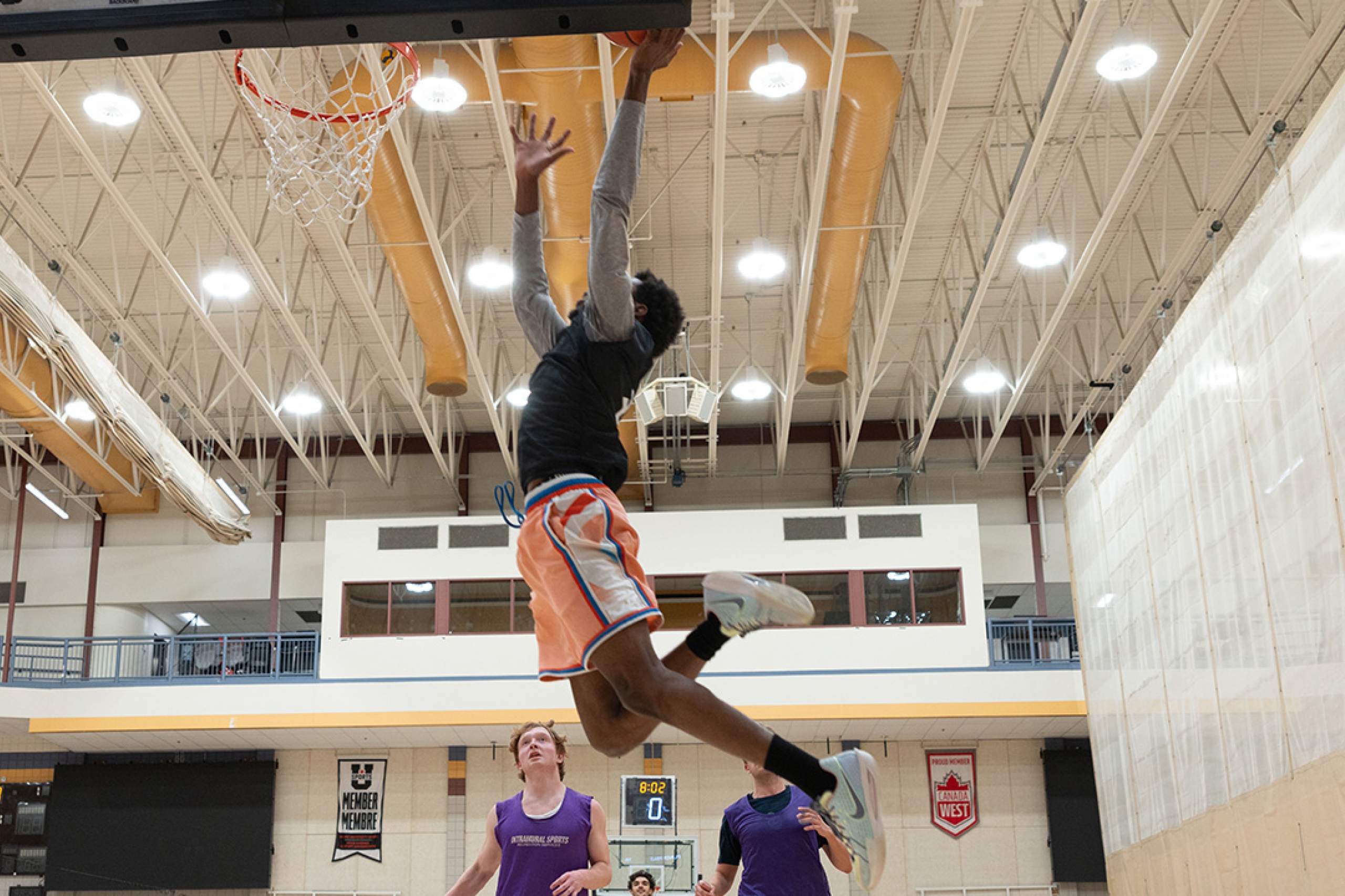 An intramural basketball player taking it to the net in a game